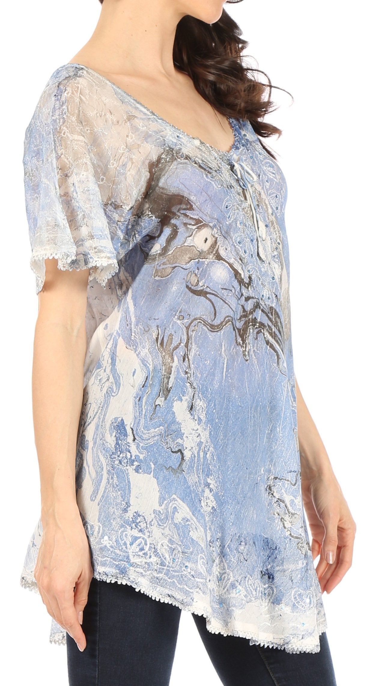 Woman wearing a blue and white patterned top with lace sleeves on a white background
