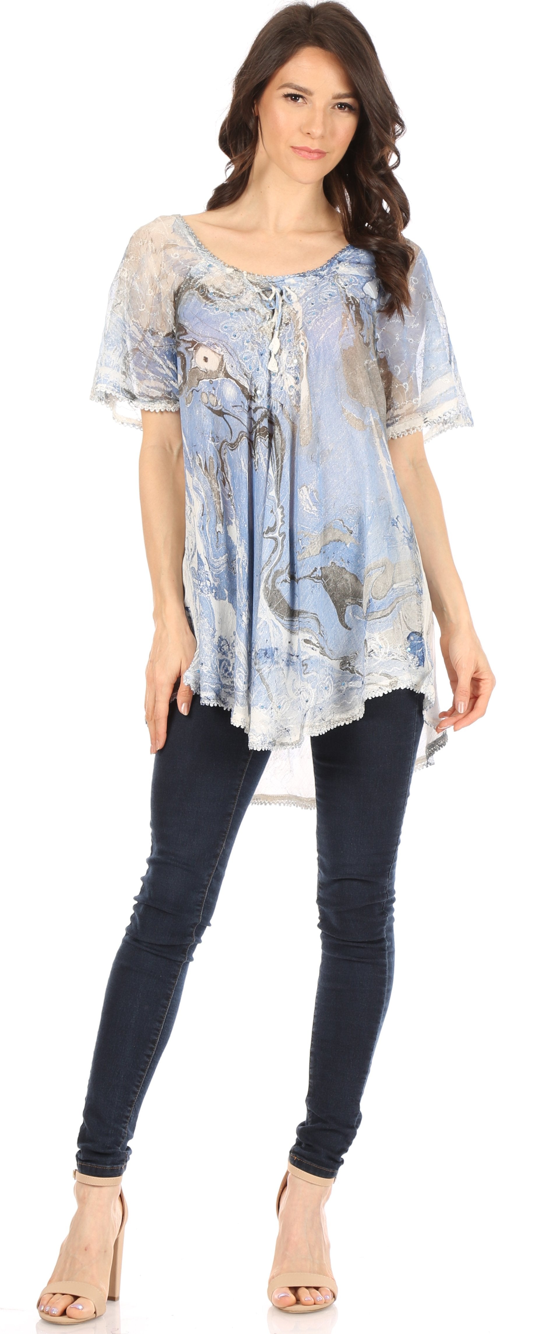 Woman wearing a light blue floral patterned top and dark blue jeans on a white background