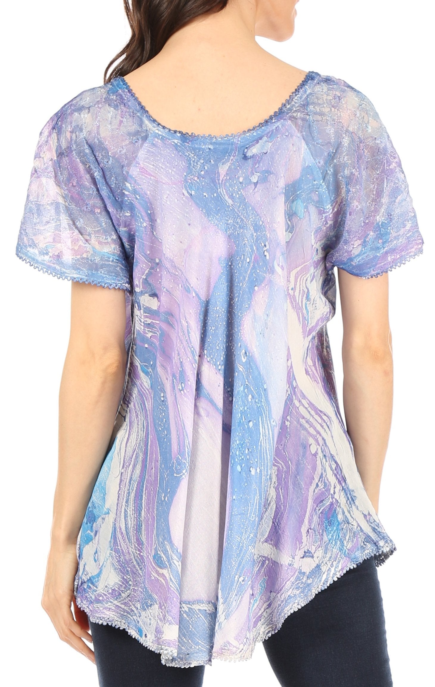 Woman wearing a short-sleeve, marbled patterned top with a white shirt underneath.