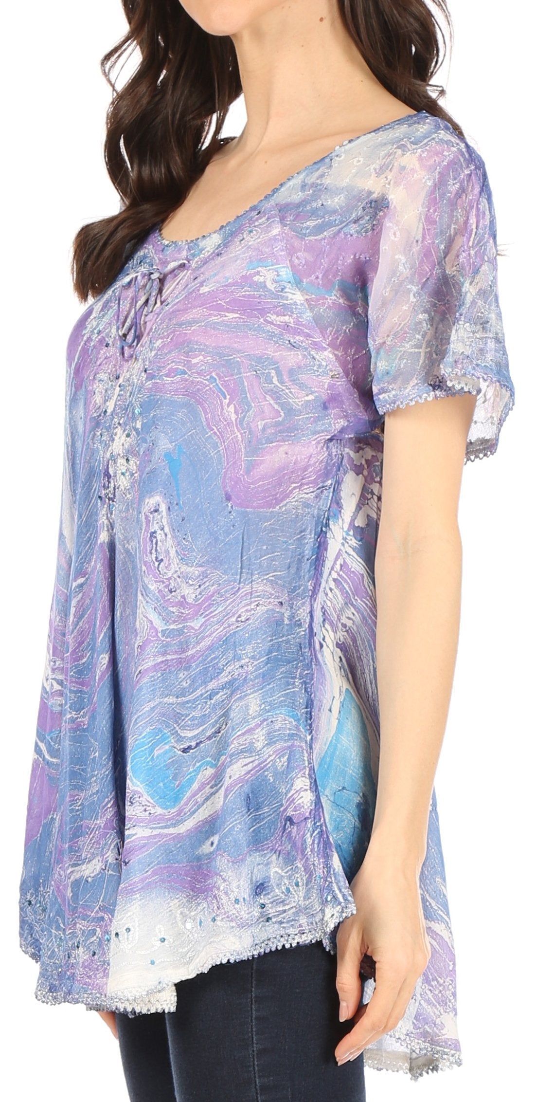 Woman wearing a colorful, patterned blouse with short sleeves.