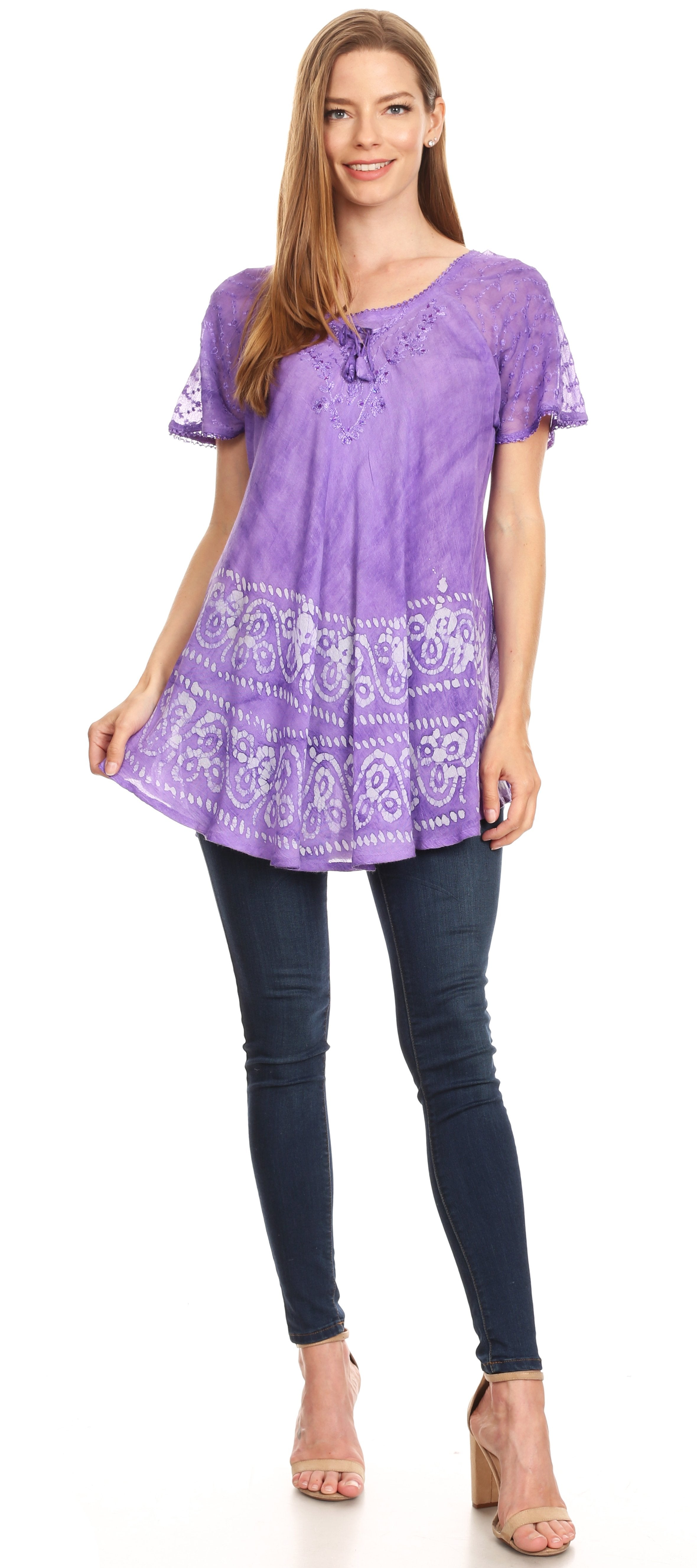 Woman wearing a purple lace-up top and dark jeans on a white background