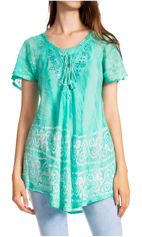 Woman wearing a turquoise lace top with white patterns on a white background