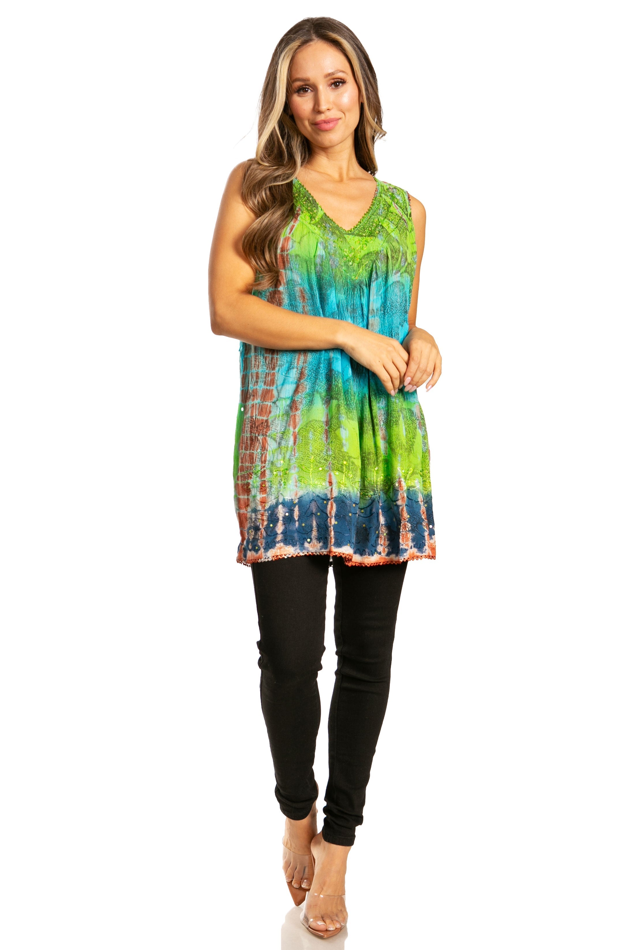 Woman wearing a colorful tie-dye sleeveless top and black pants on a white background
