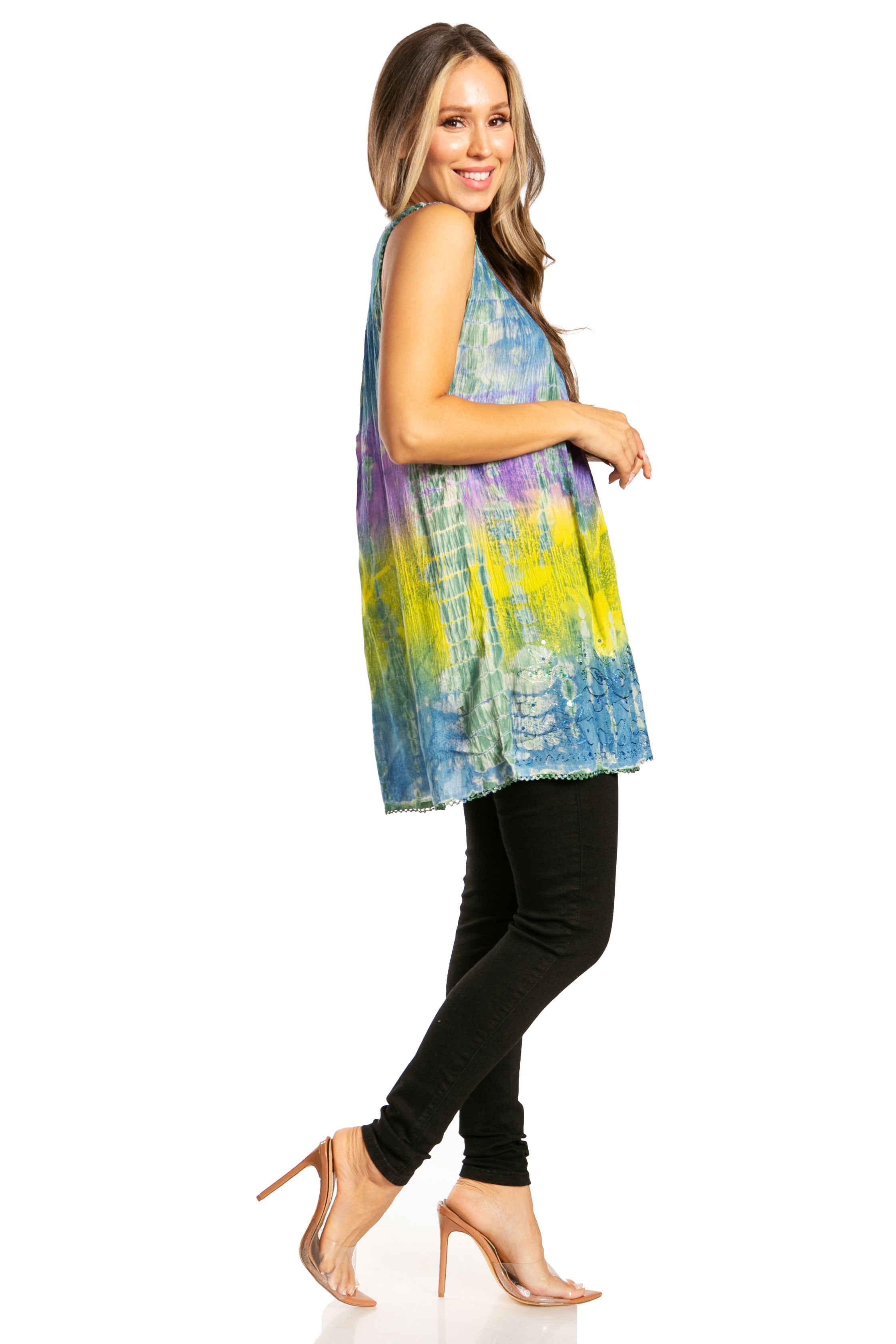 Woman wearing a colorful sleeveless top and black pants on a white background