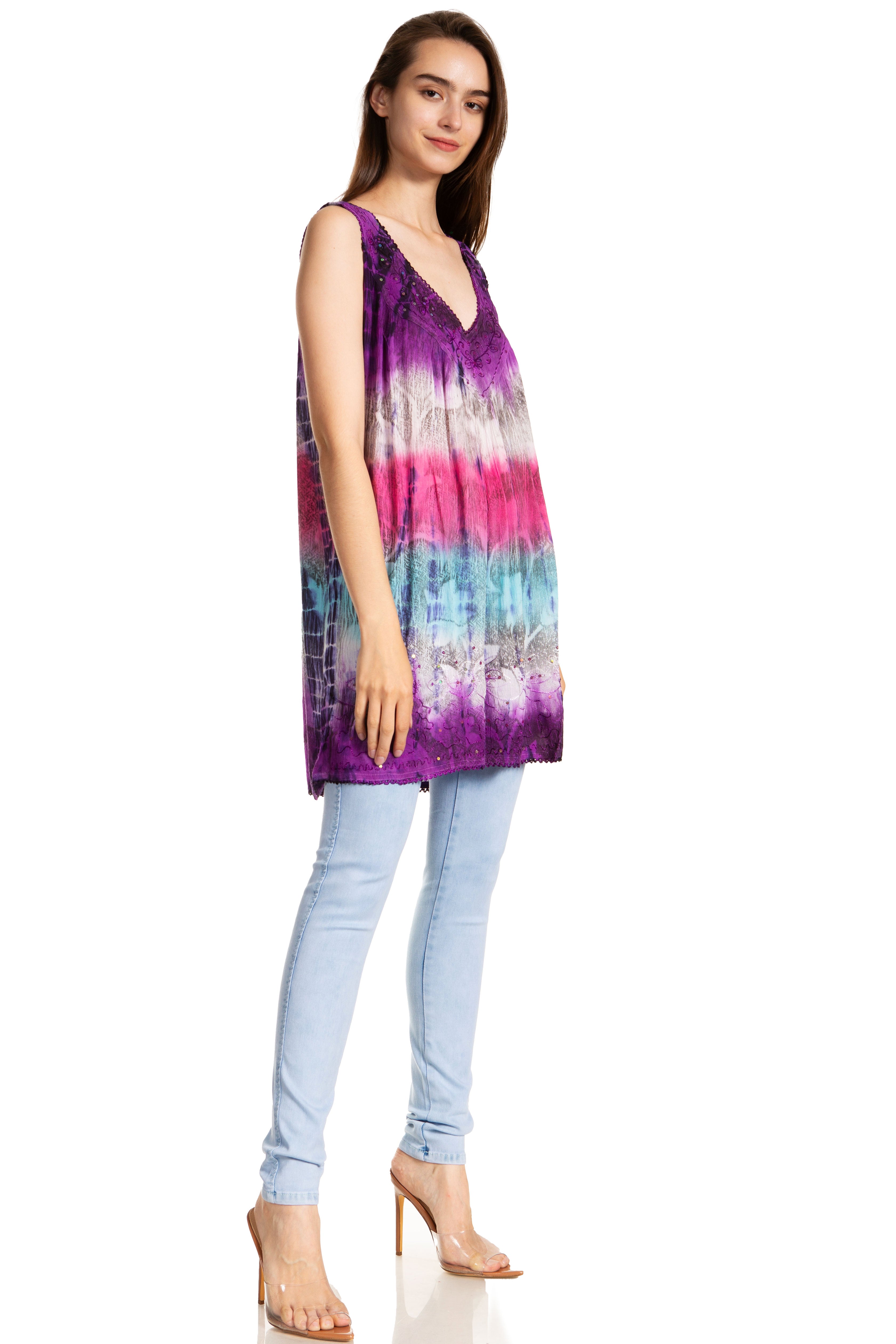 Woman wearing a tie-dye sleeveless top and light blue jeans on a white background