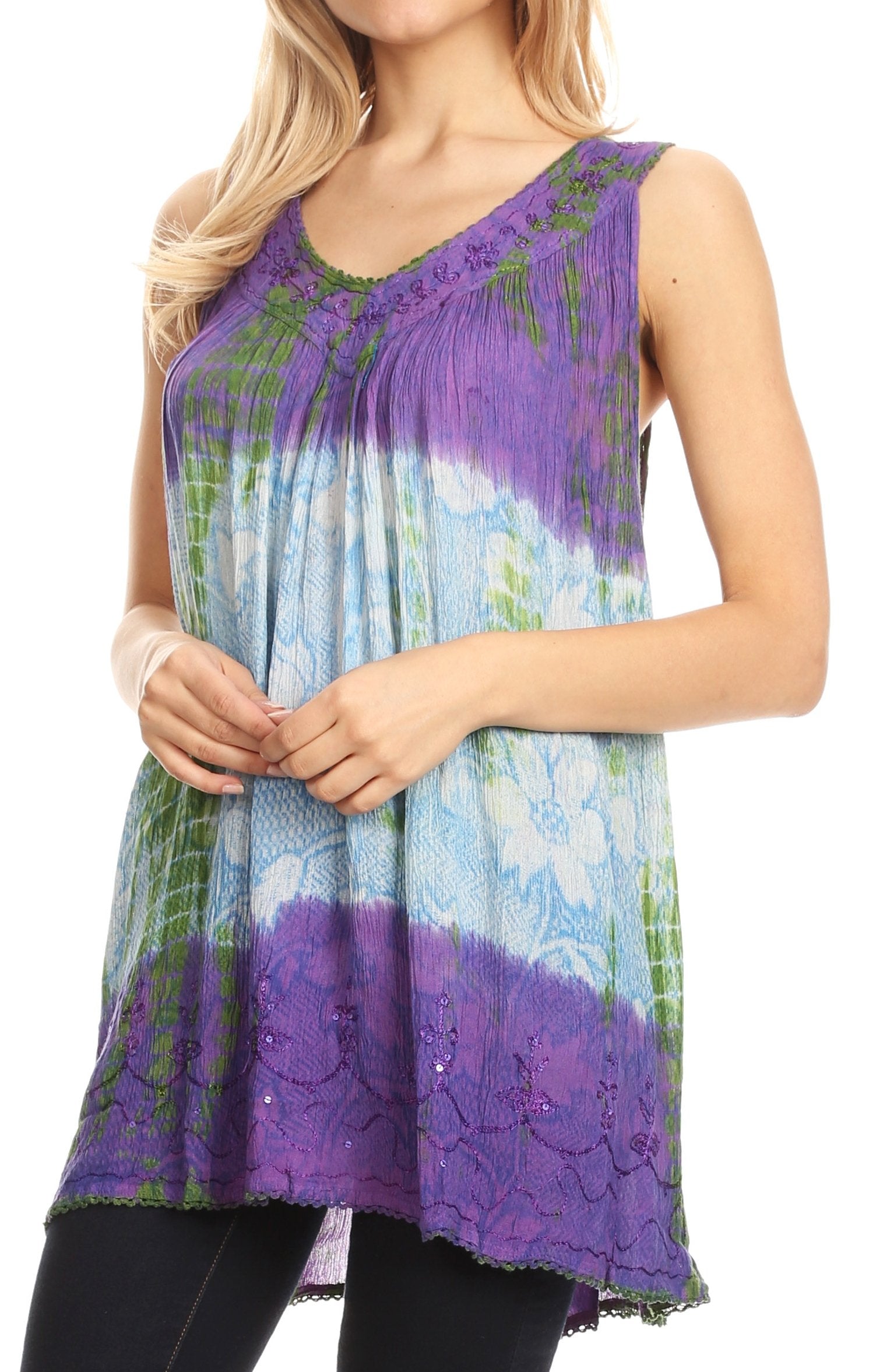 Woman wearing a sleeveless, tie-dye top with purple and blue patterns on a white background