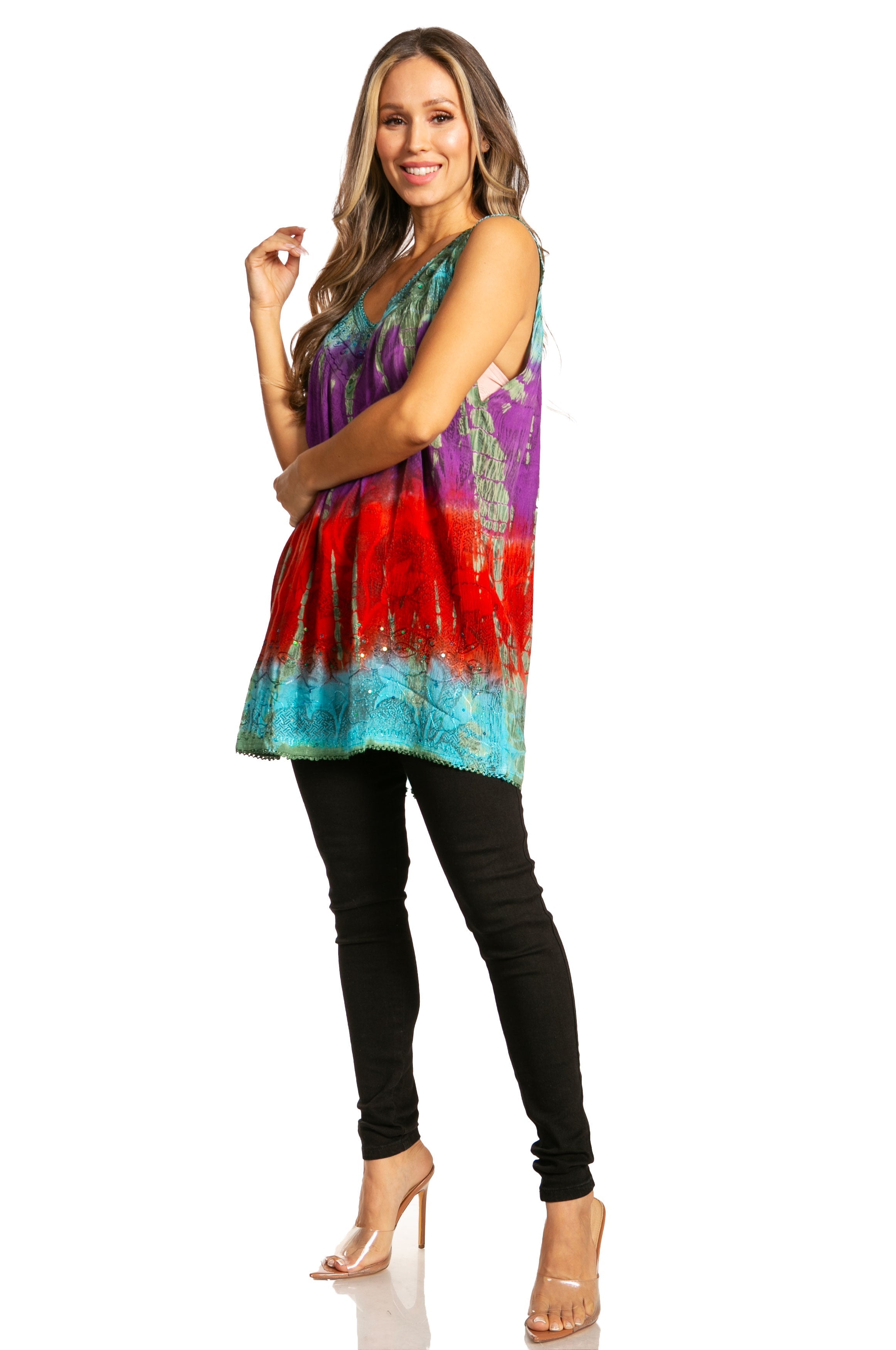 Woman wearing a colorful tie-dye top and black pants on a white background