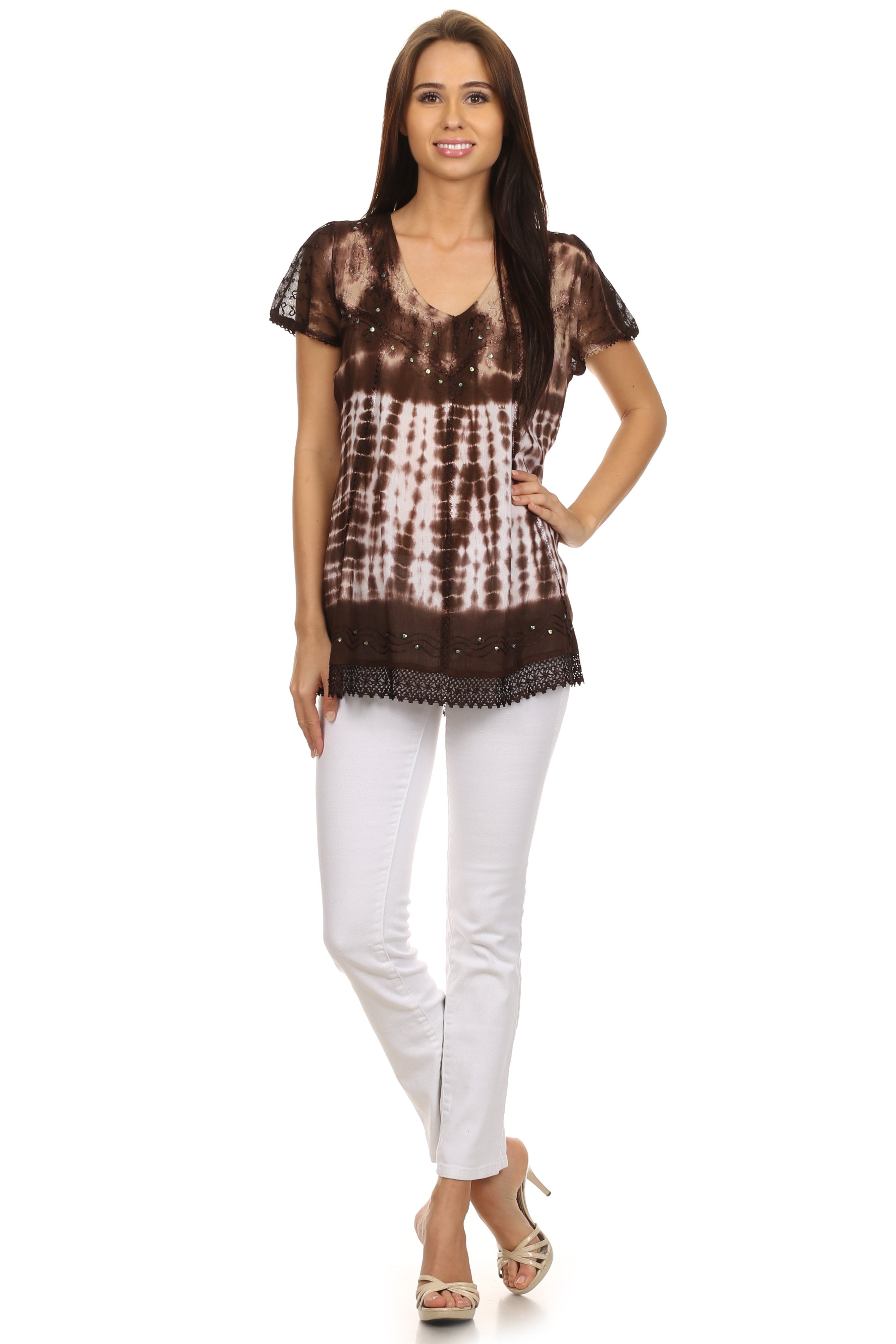 Woman wearing a brown tie-dye top and white pants on a white background