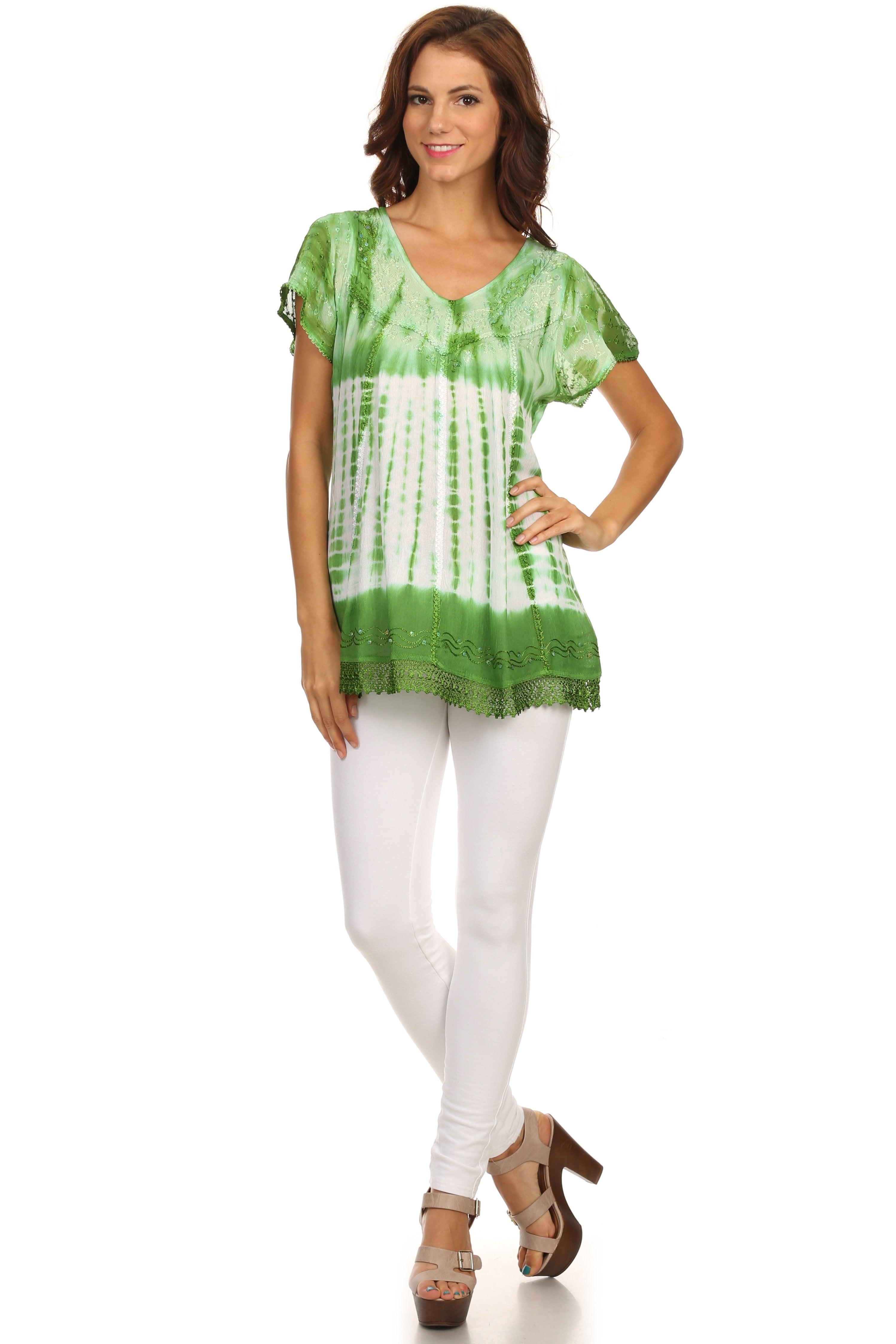 Woman wearing a green and white tie-dye top with white pants on a white background