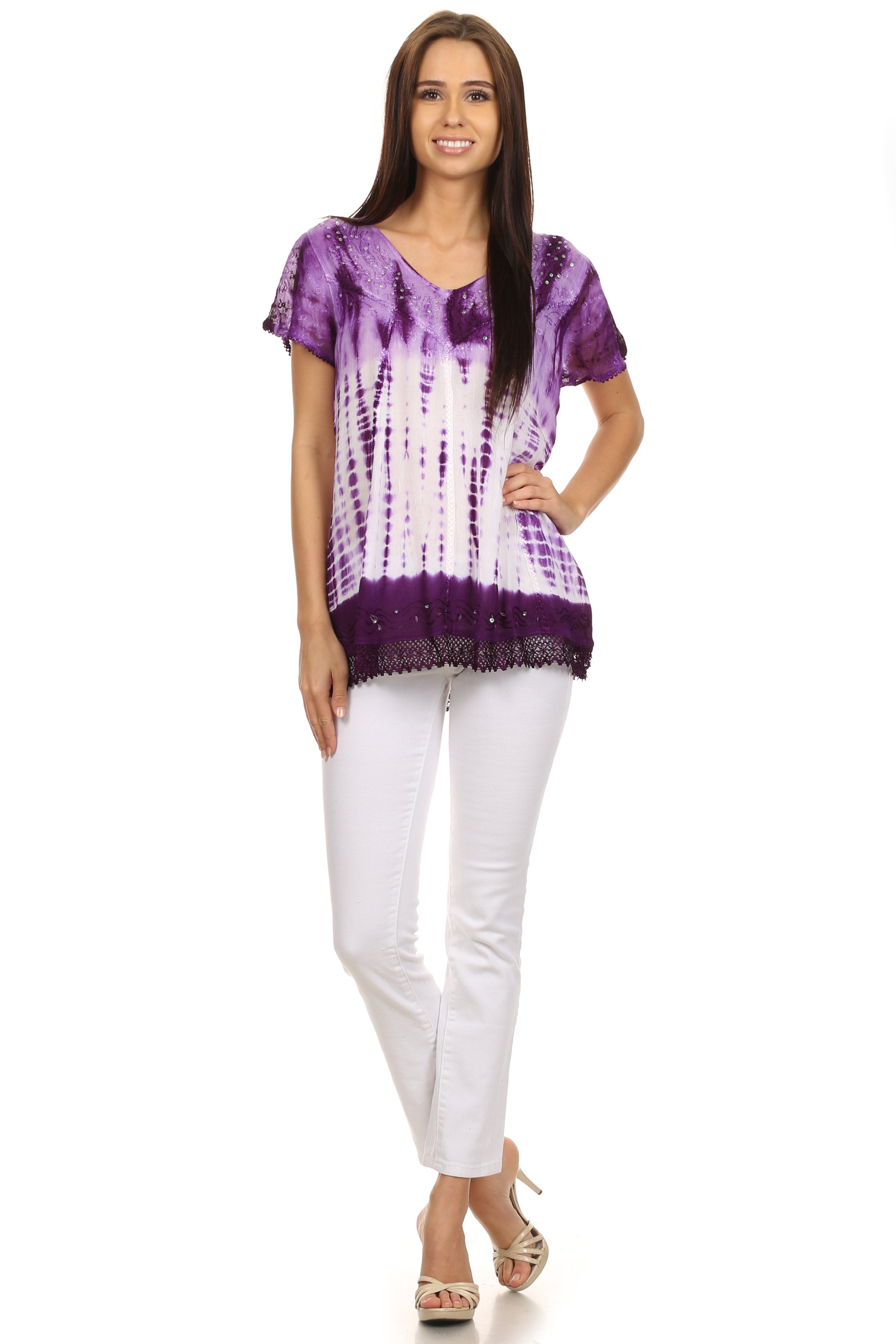 Woman wearing a purple tie-dye shirt and white pants on a white background