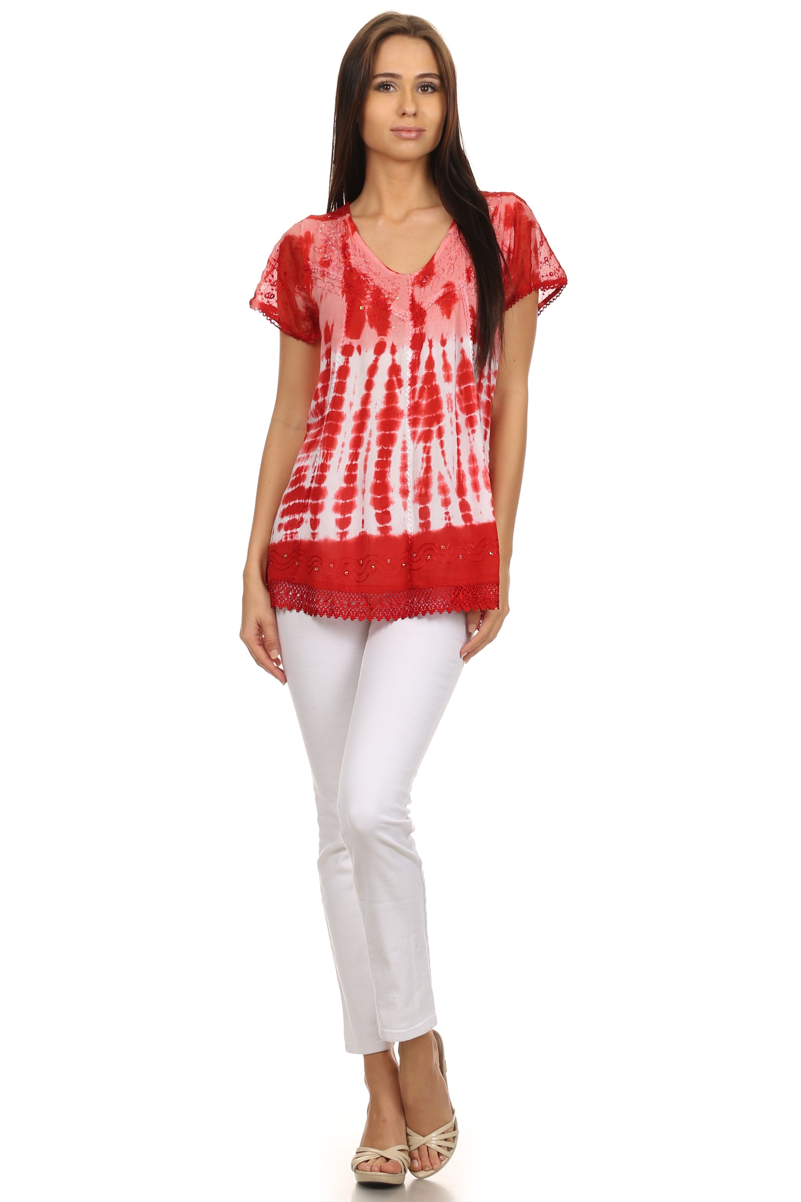 Woman wearing a red tie-dye top and white pants on a white background