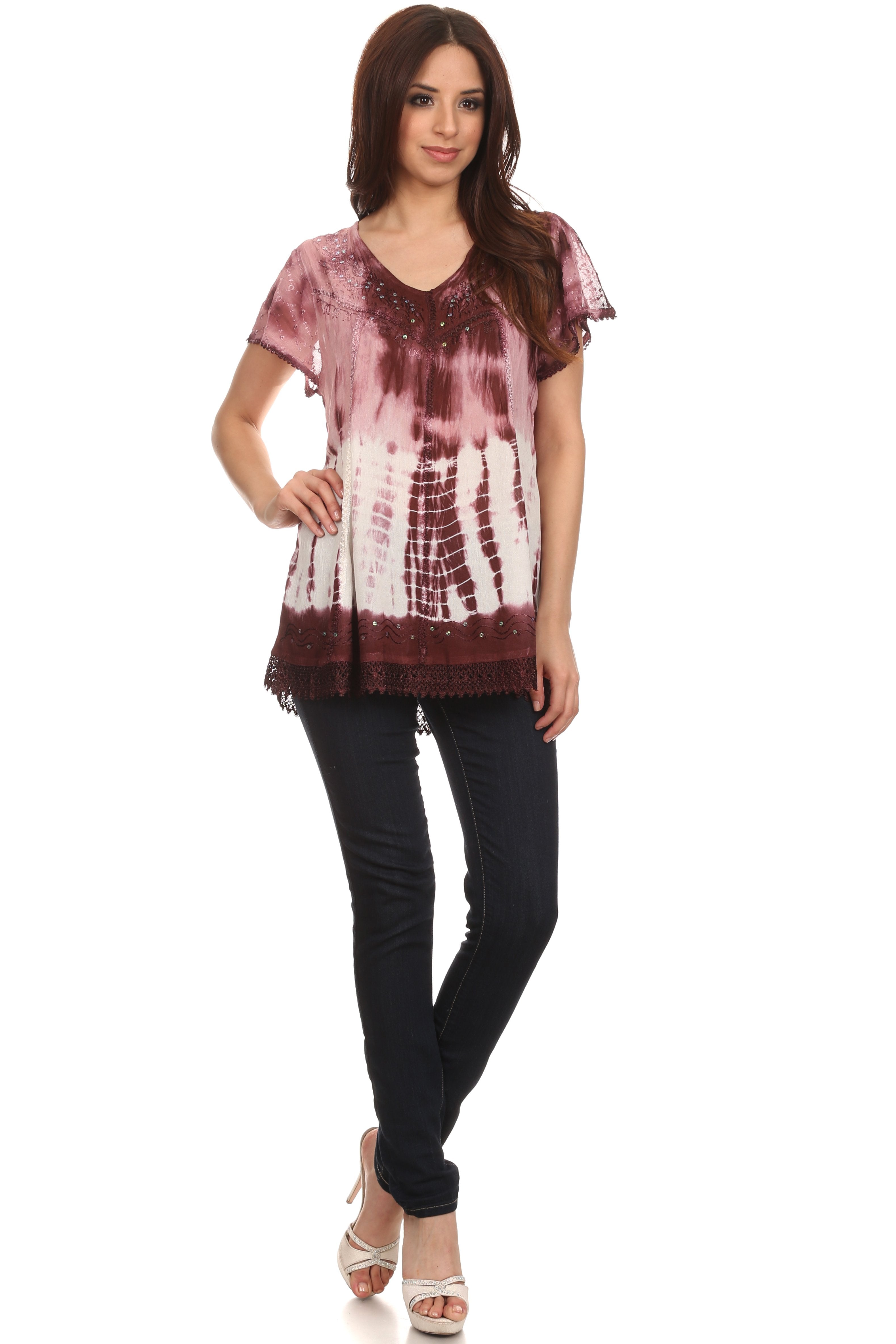 Woman wearing a tie-dye shirt and black pants on a white background