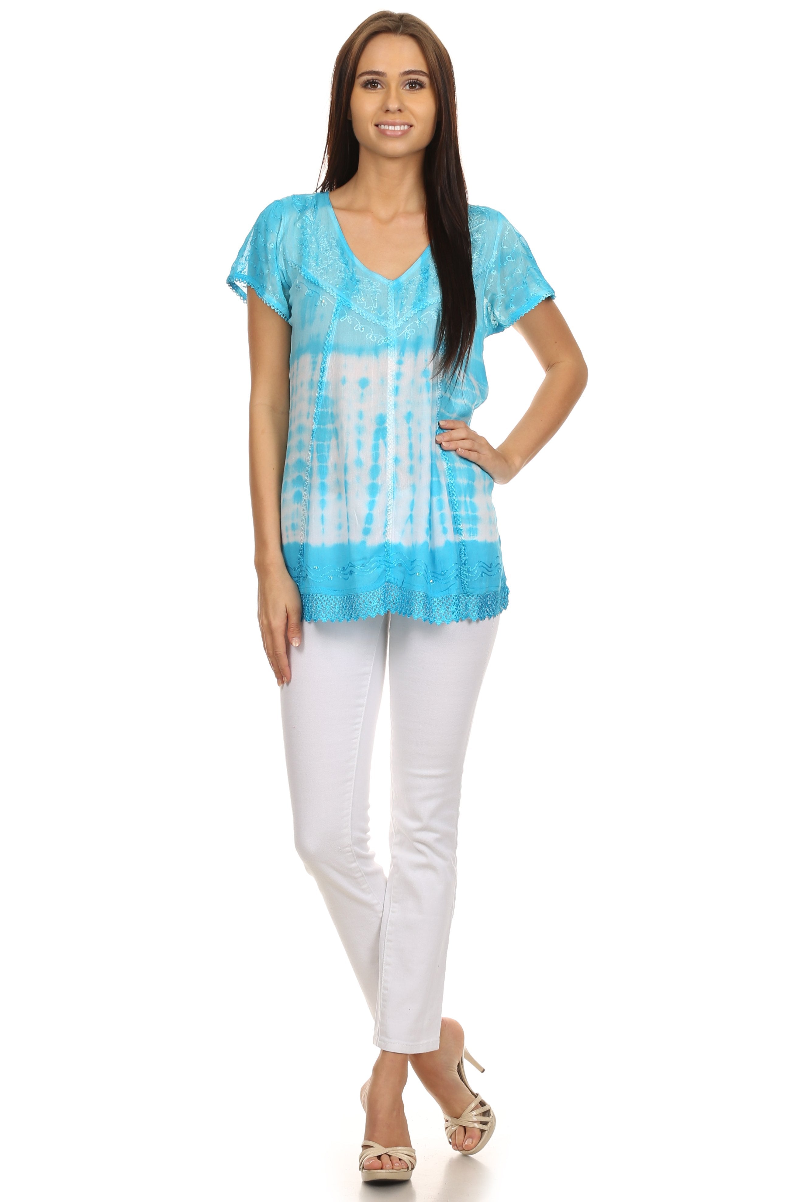 Woman wearing a blue tie-dye top and white pants on a white background