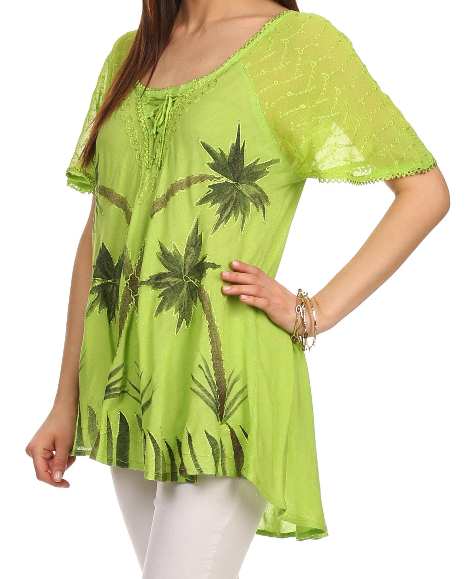 Green blouse with palm tree design worn by a person on a white background