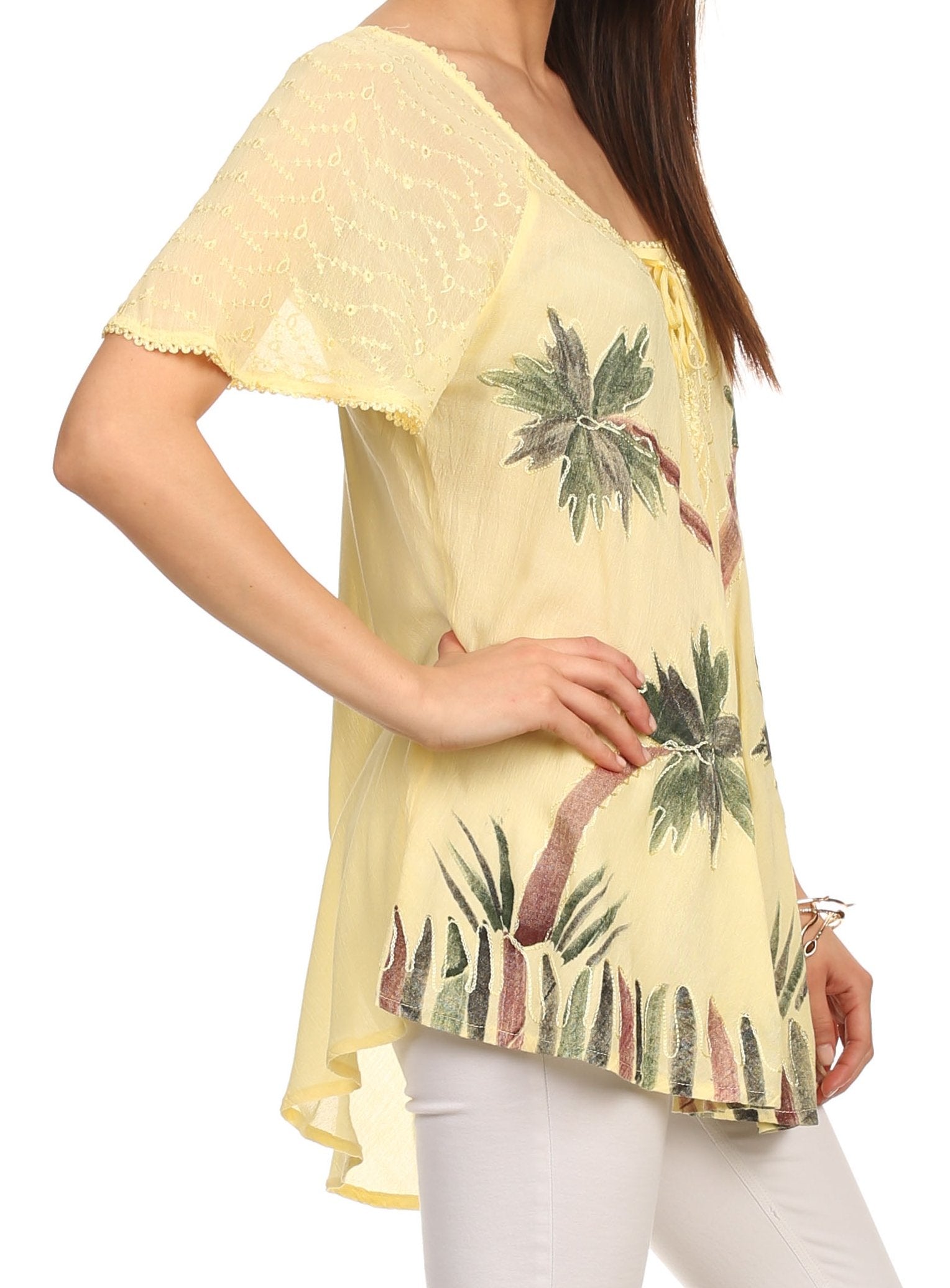 Yellow floral printed top worn by a person on a white background