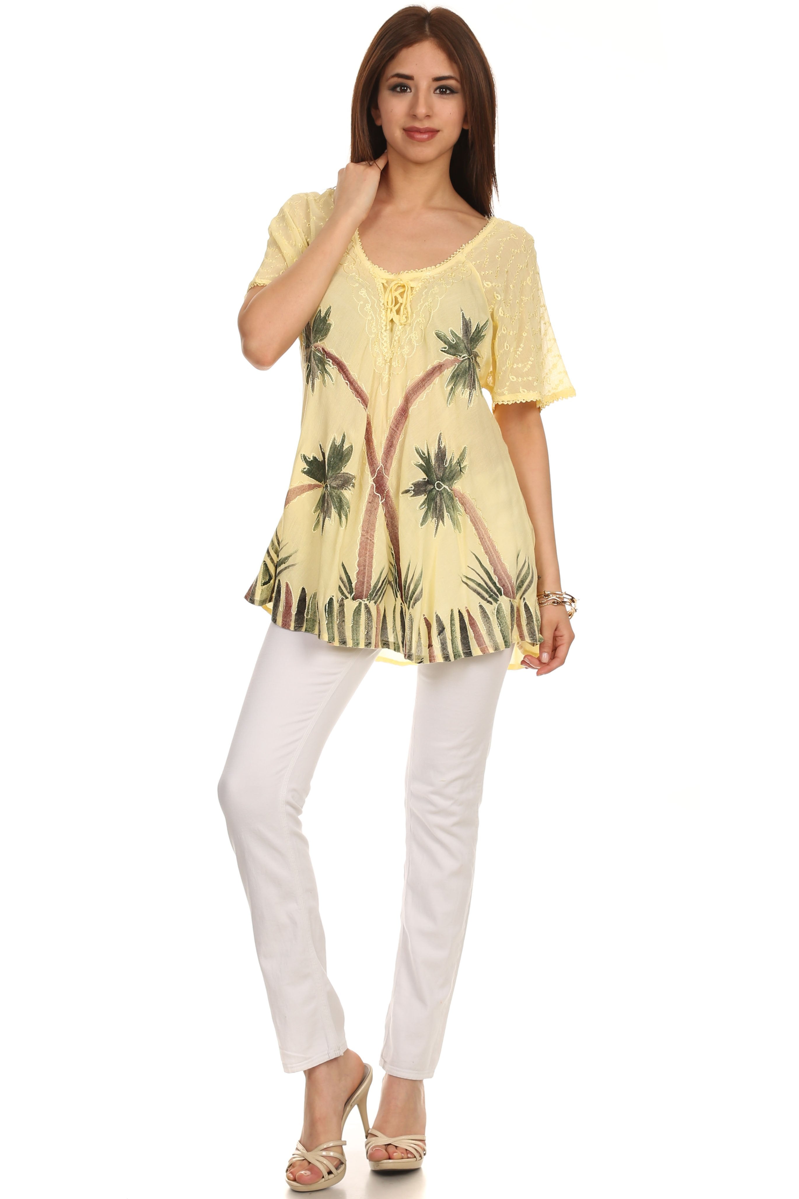 Woman wearing a yellow floral top and white pants on a white background