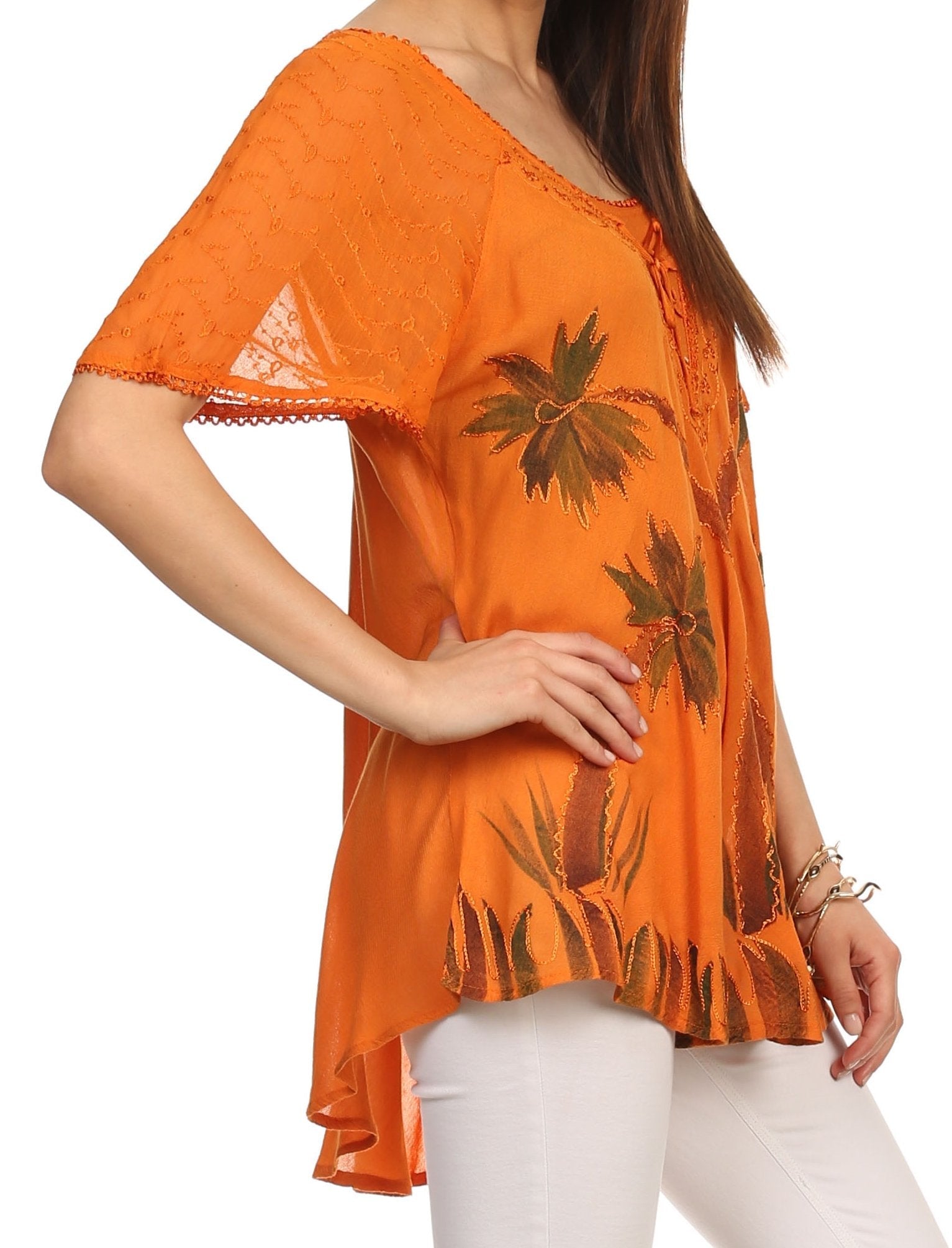 Orange lace top with leaf patterns worn by a person on a white background