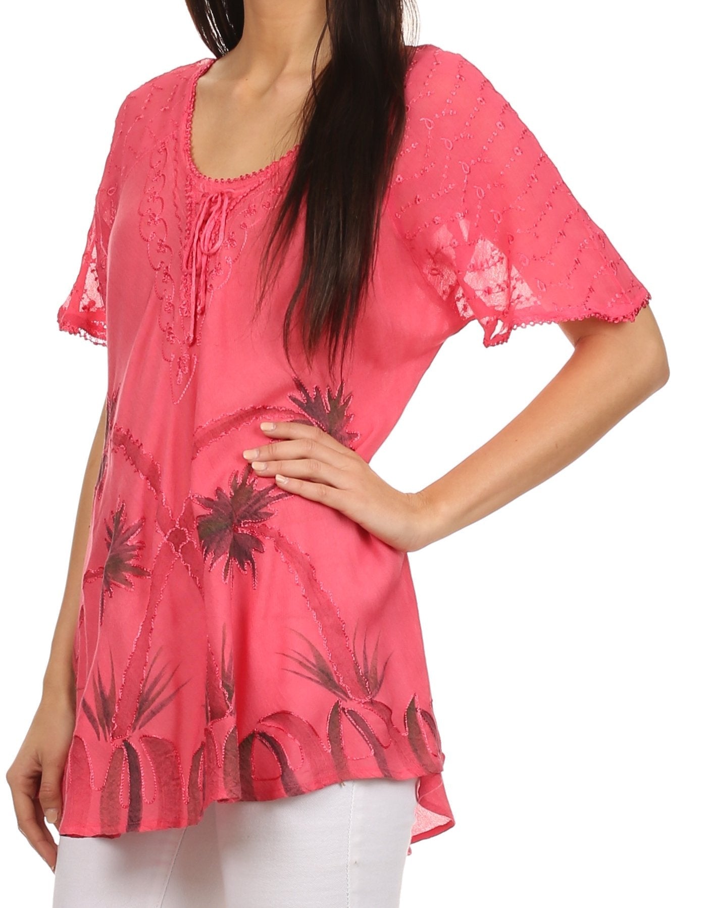 Woman wearing a pink blouse with black floral patterns on a white background