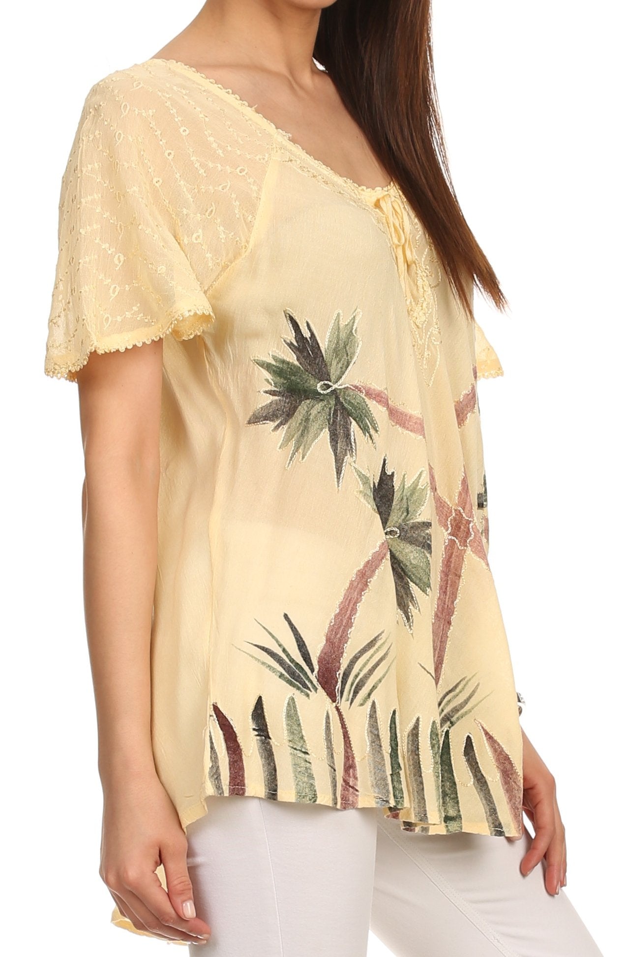Woman wearing a yellow lace top with palm tree prints on a white background