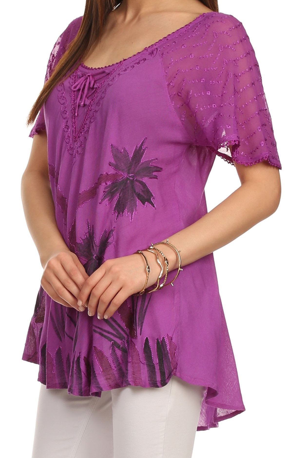 Purple blouse with floral patterns worn by a person on a white background