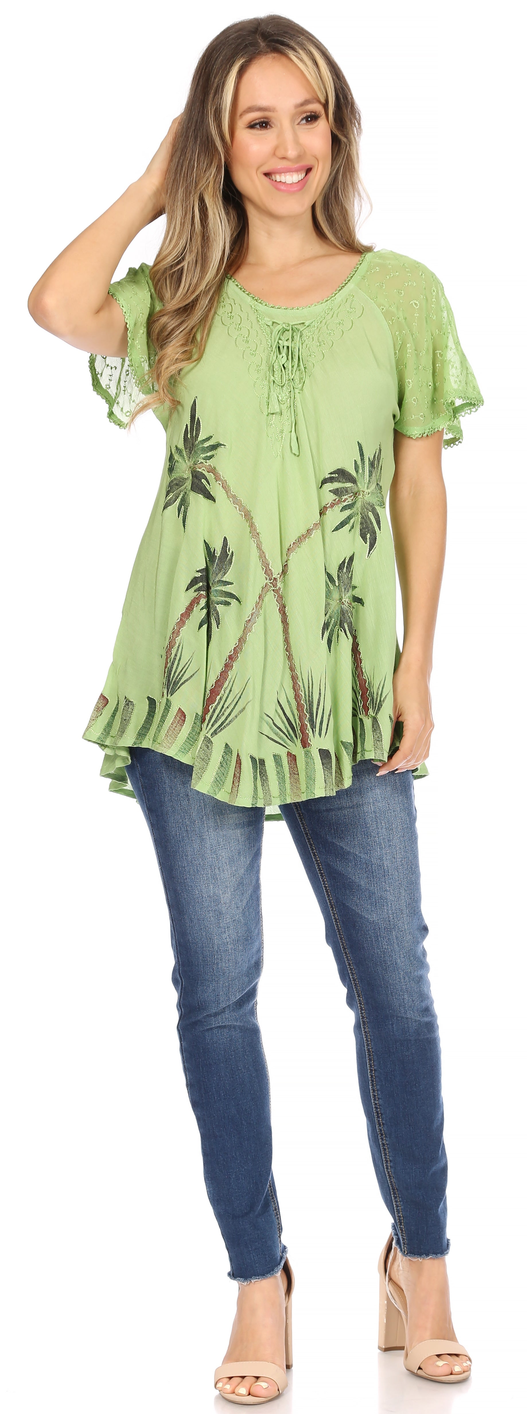 Woman wearing a green floral blouse and blue jeans on a white background