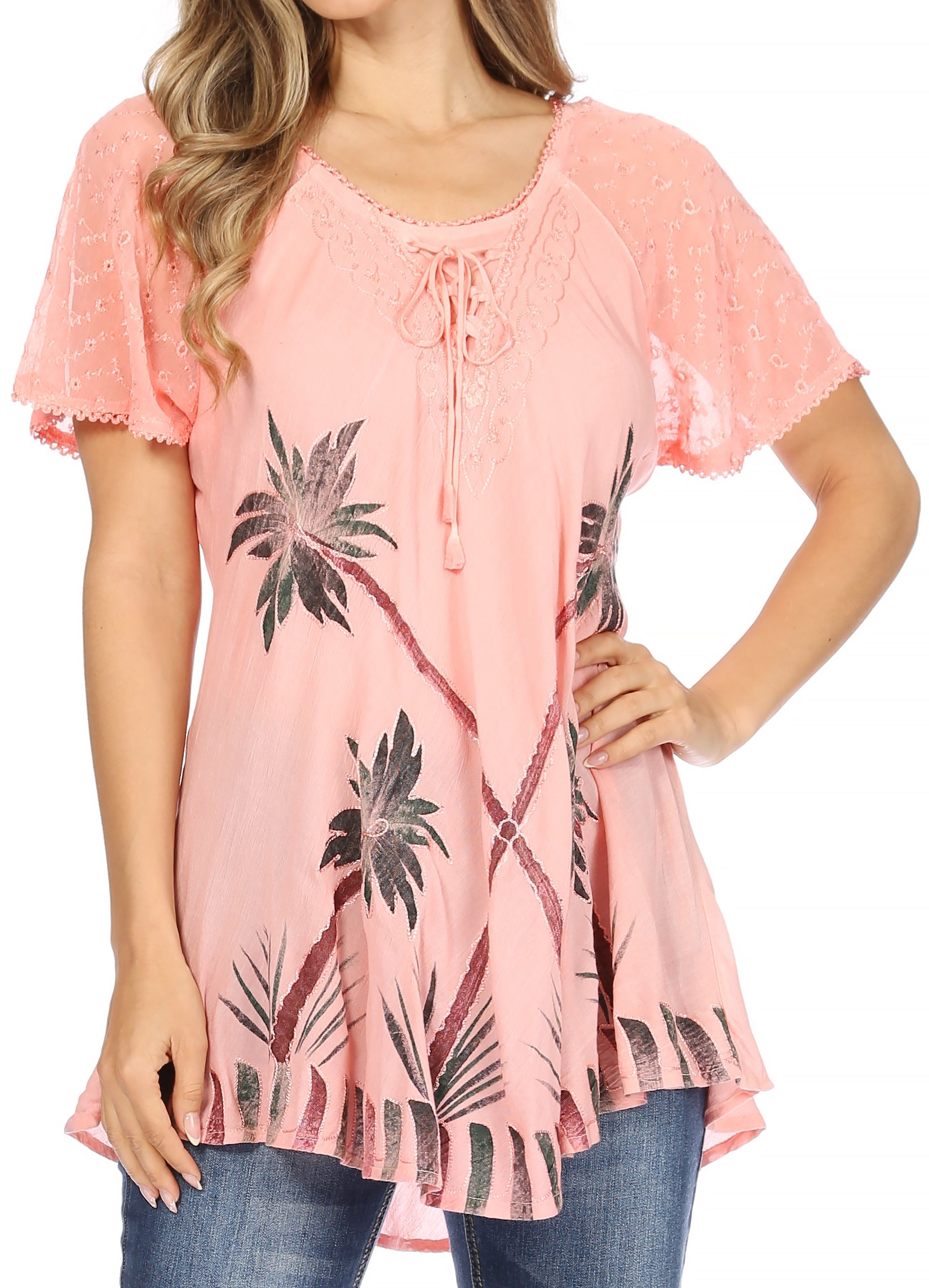 Woman wearing a pink lace-trimmed top with palm tree pattern on a white background