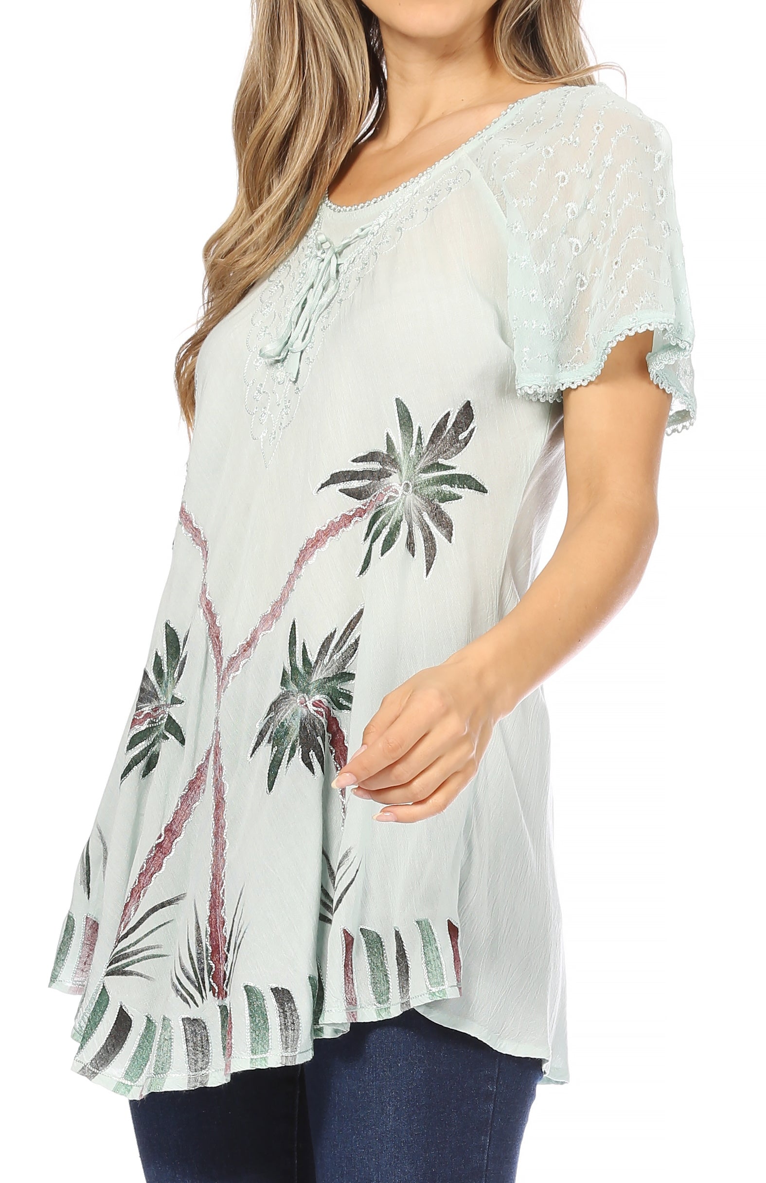 Woman wearing a light blue blouse with palm tree pattern