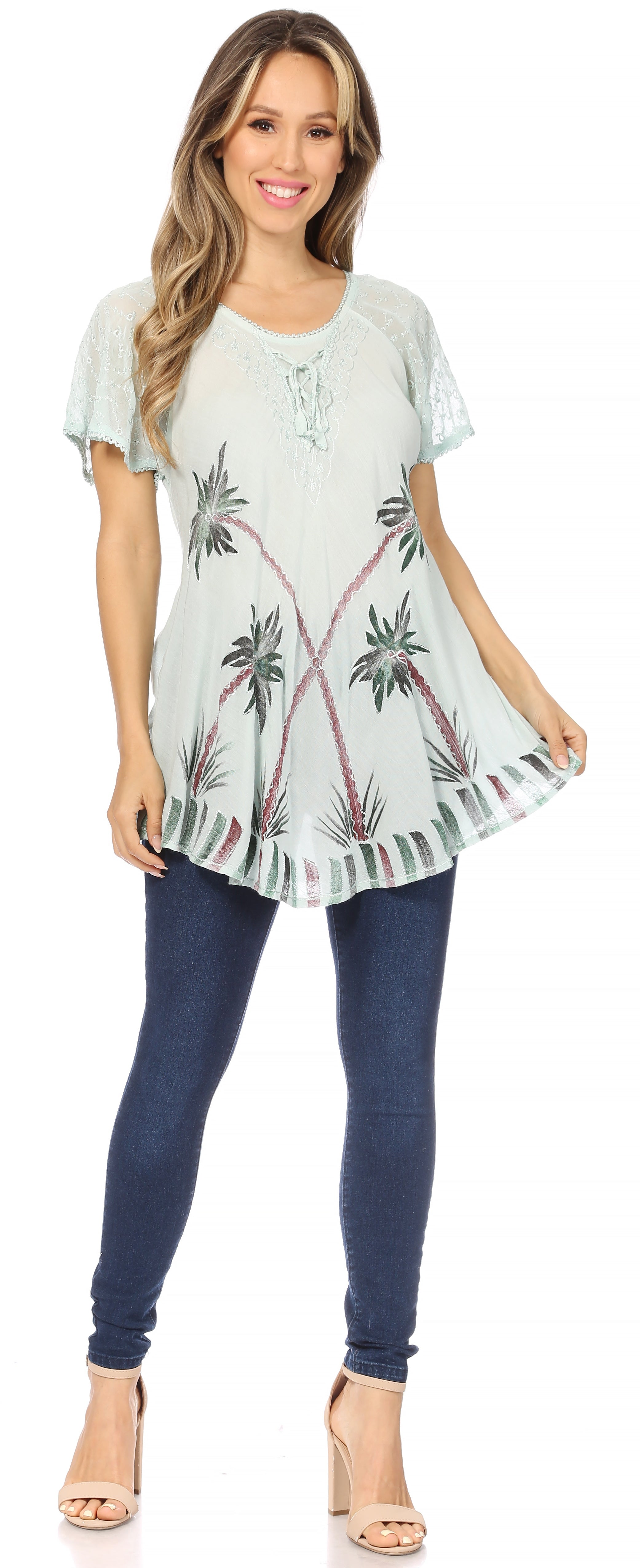 Woman wearing a light green floral tunic and navy leggings on a white background