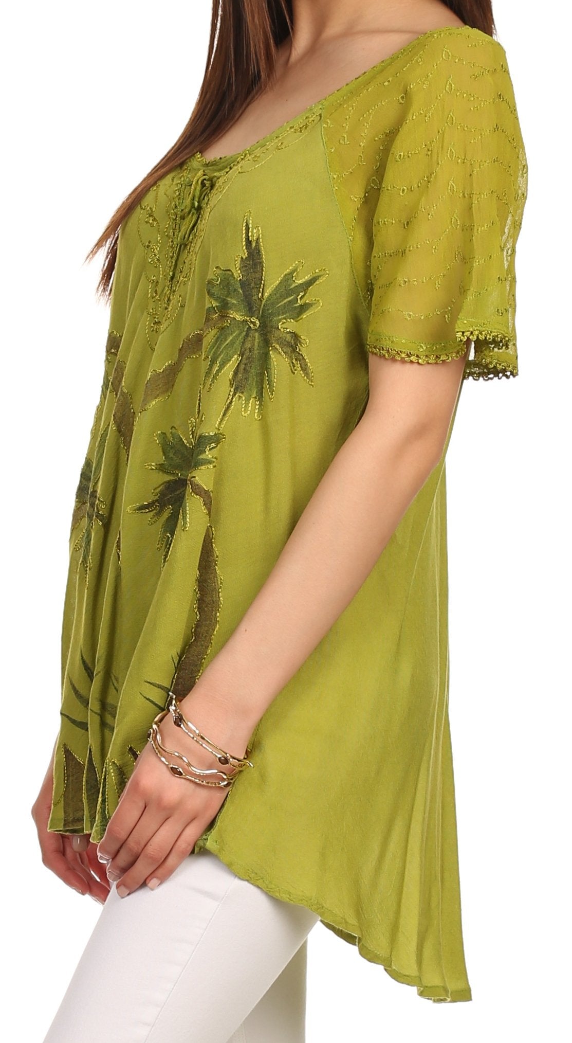 Green embroidered top worn by a person on a white background