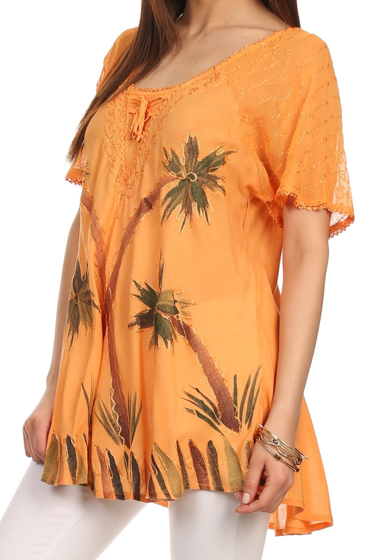 Orange blouse with palm tree design worn by a person on a white background