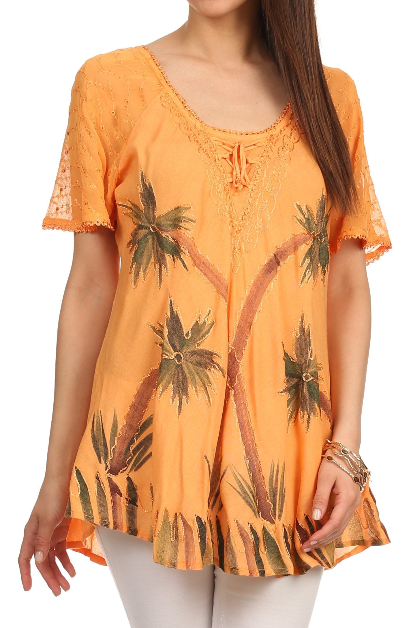 Orange top with palm tree pattern worn by a model on a white background