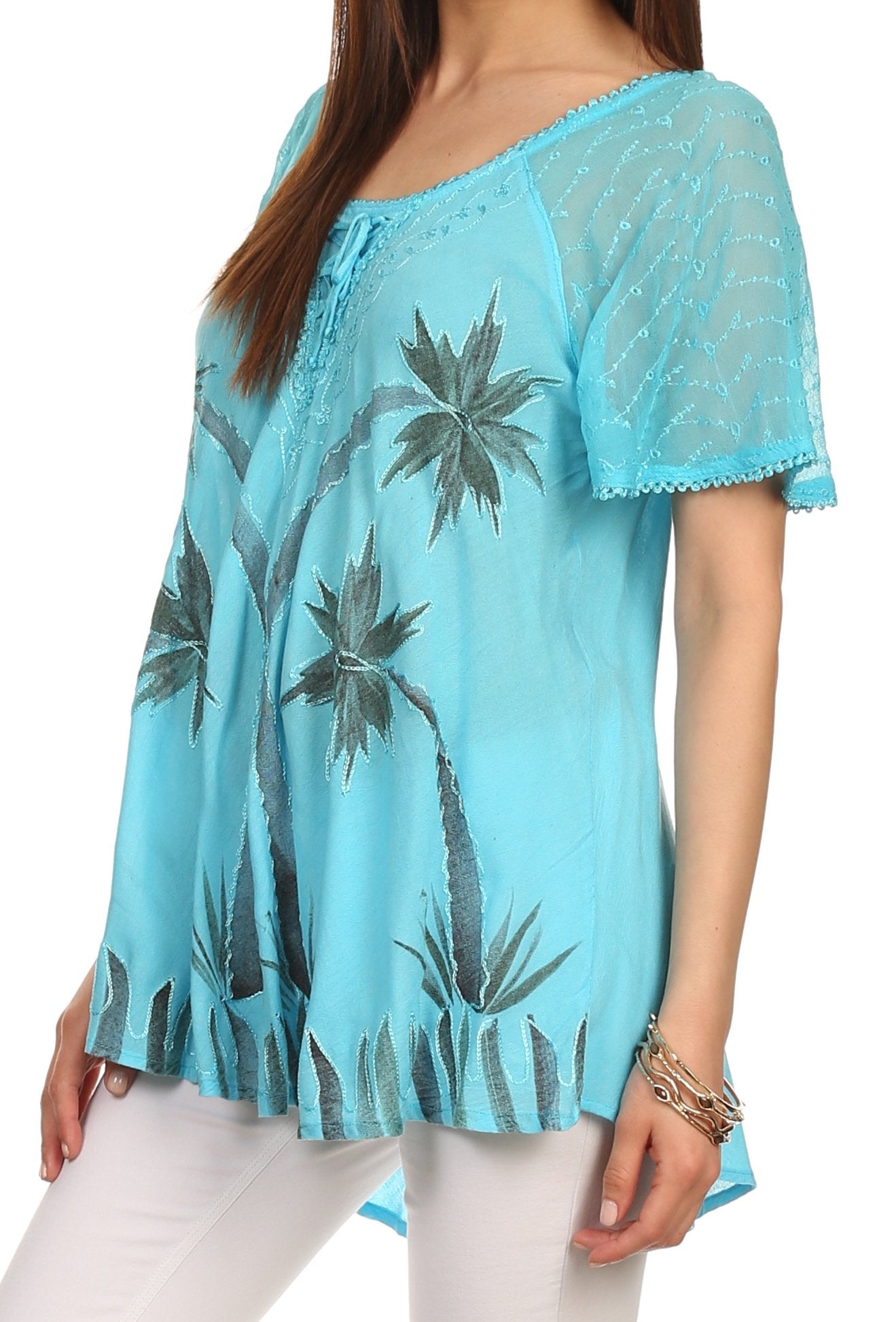Light blue lace top with palm tree design worn by a person on a white background
