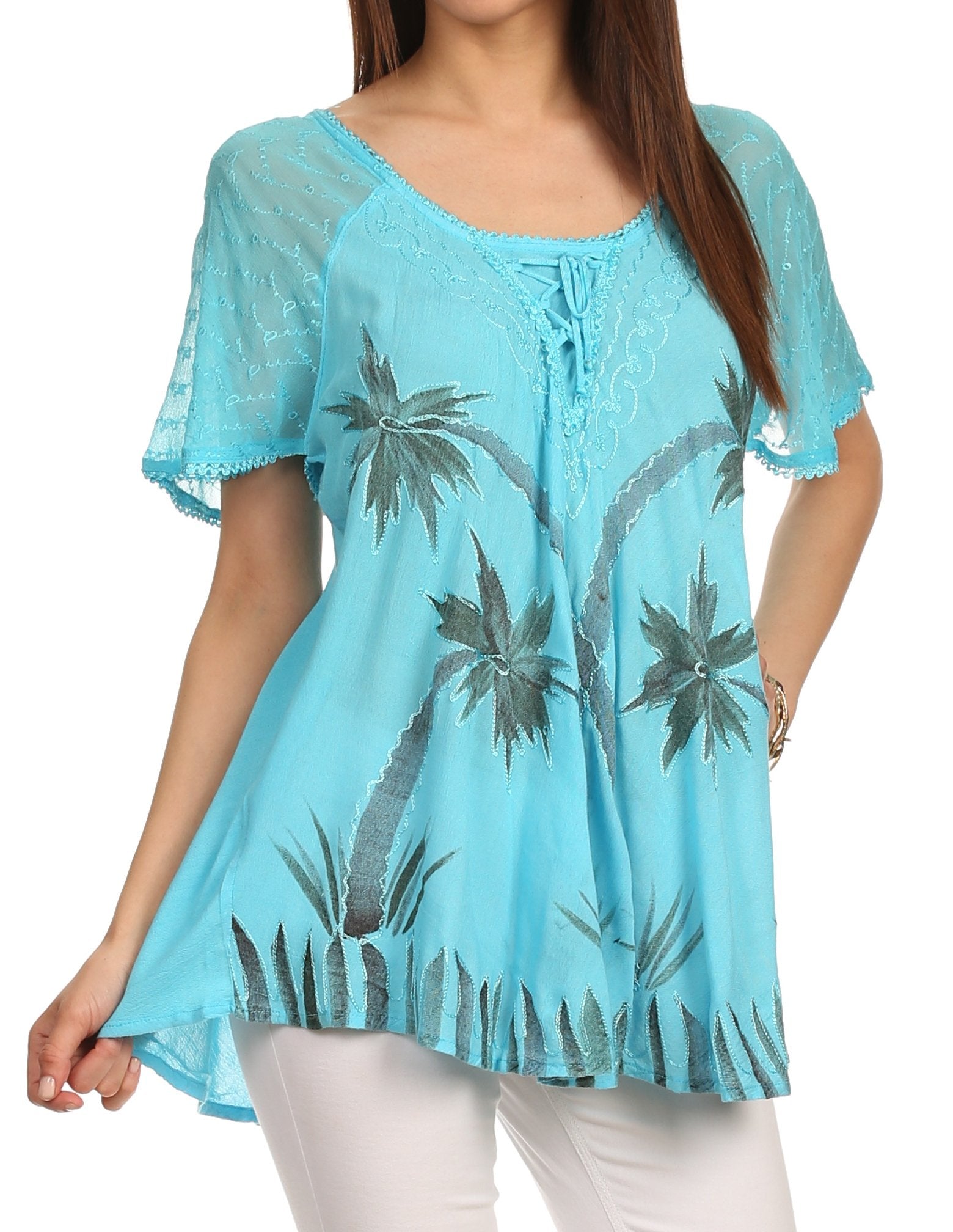 Woman wearing a turquoise blouse with palm tree pattern on a white background