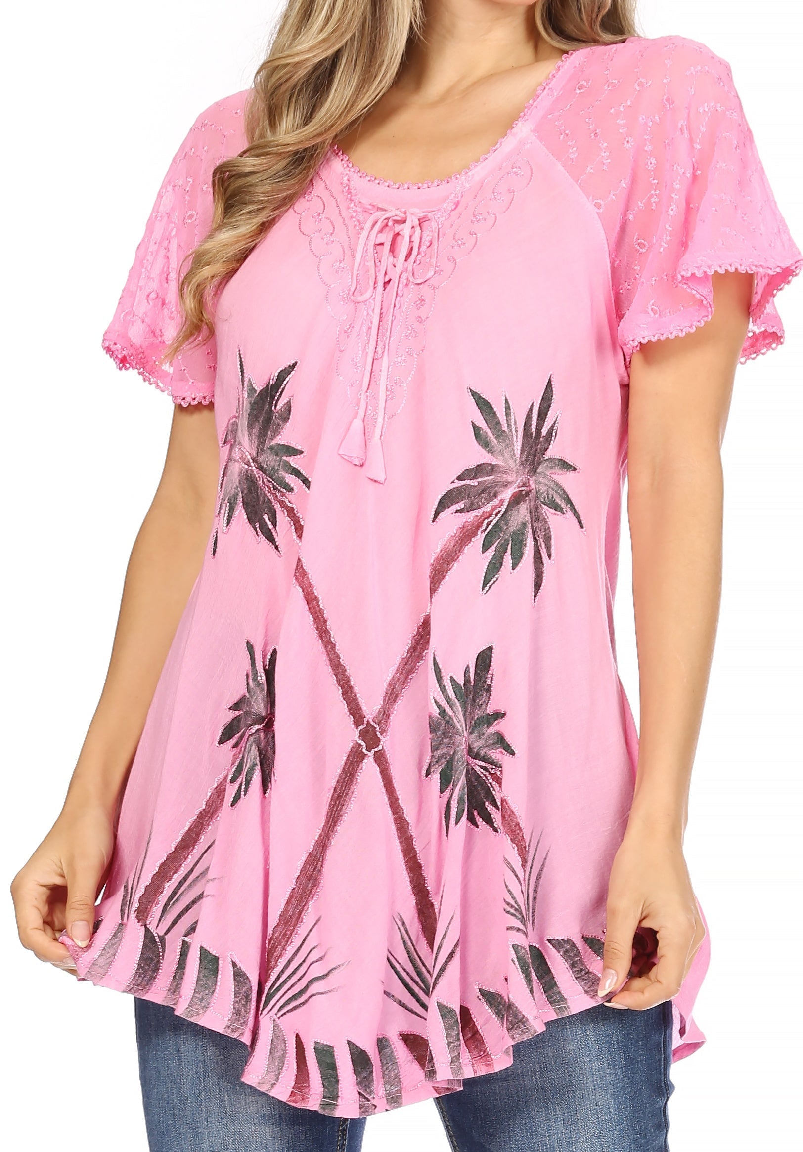 Pink blouse with palm tree patterns worn by a person on a white background