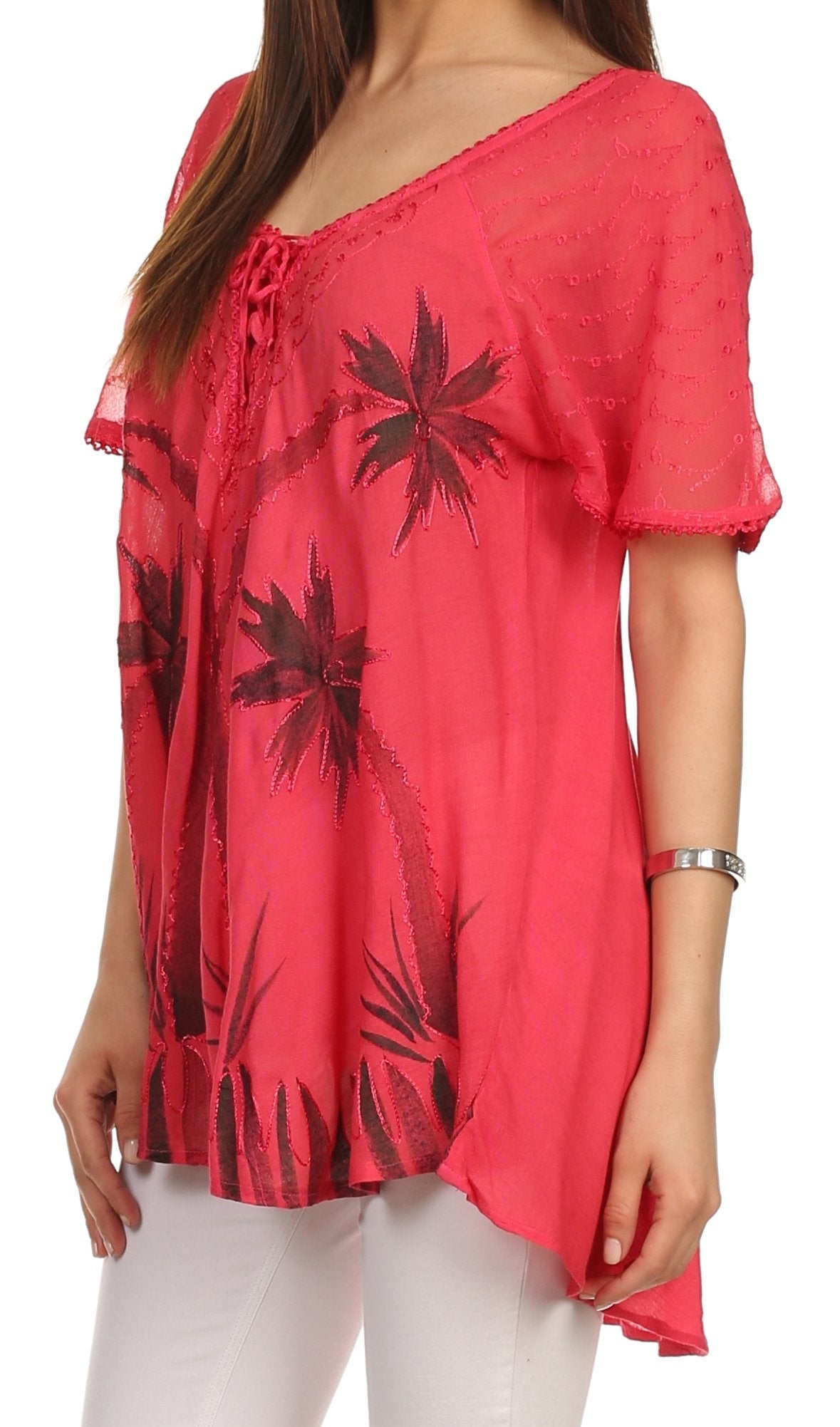Red blouse with black palm tree patterns worn by a person on a white background