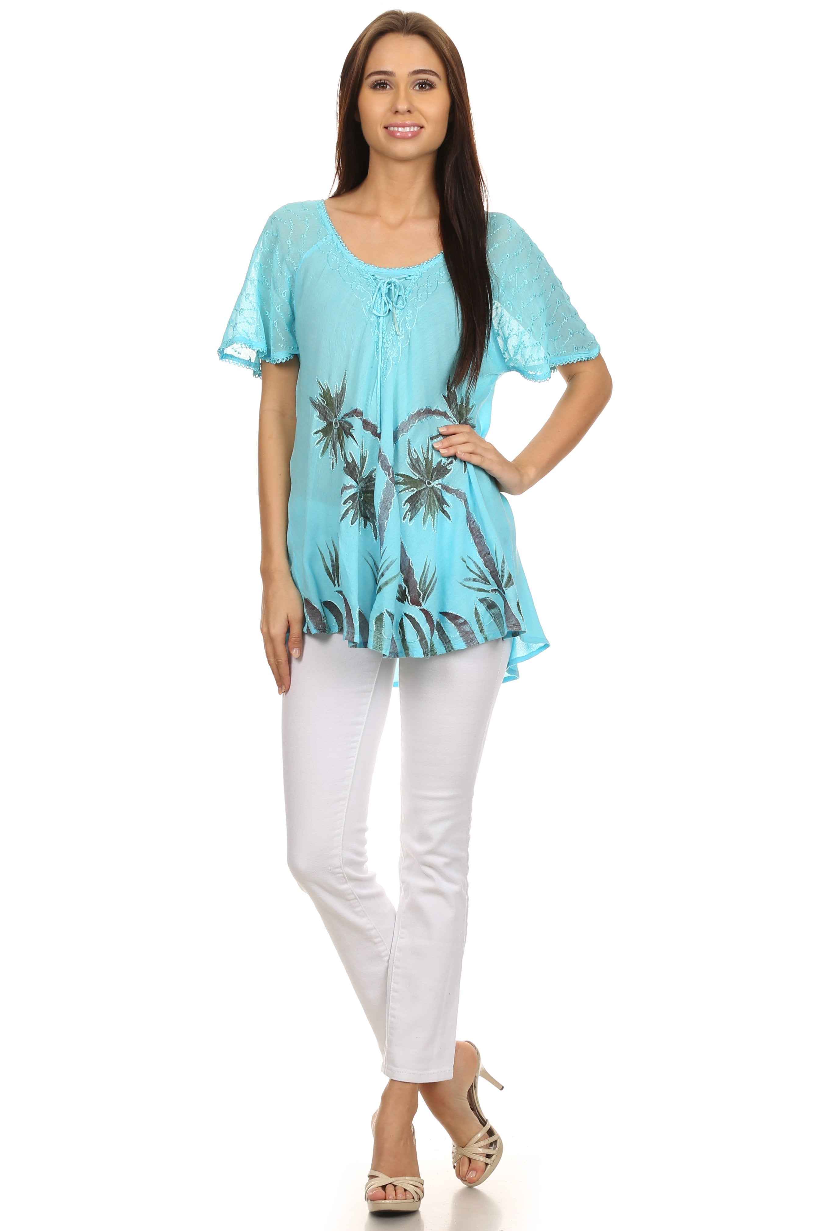 Woman wearing a light blue floral top and white pants on a white background