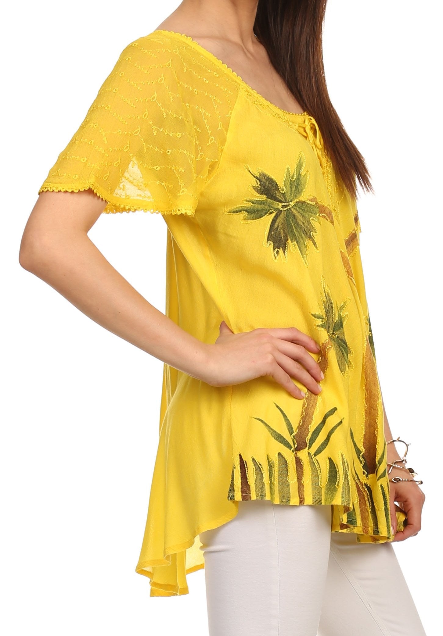 Yellow top with palm tree design worn by a person on a white background