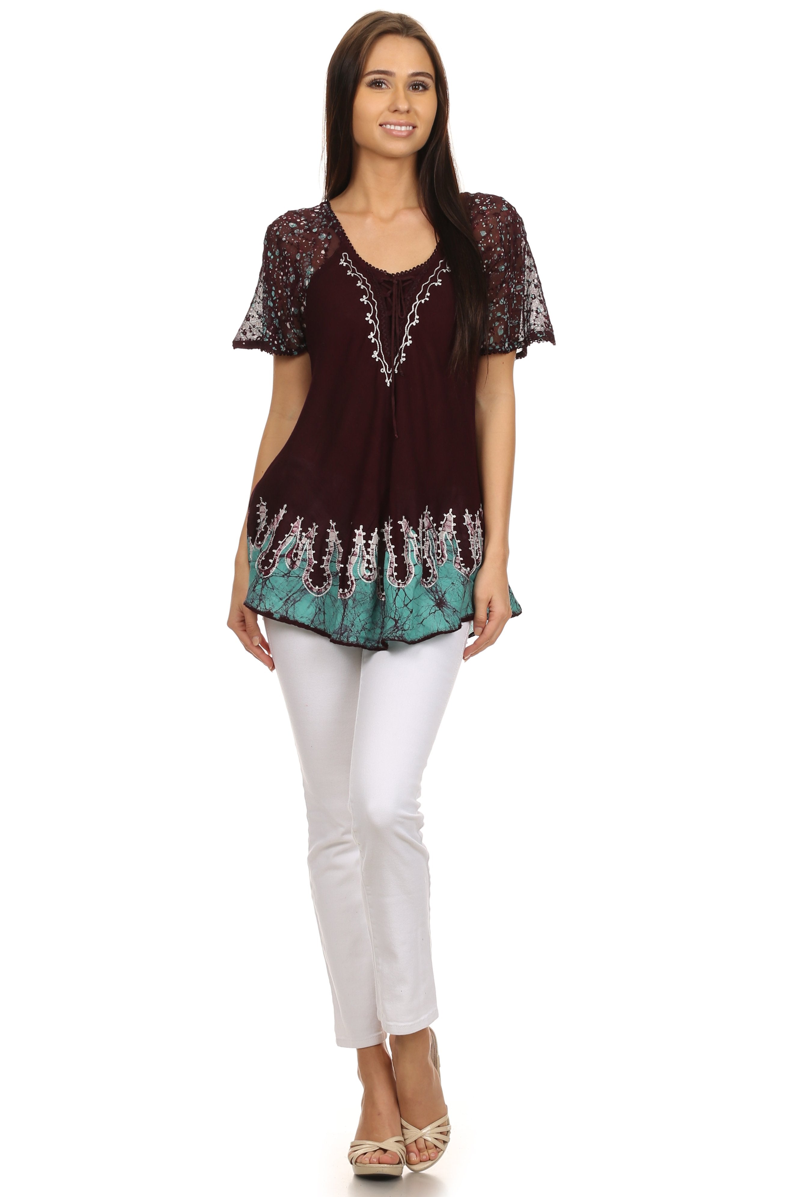 Woman wearing a maroon and green top with white pants on a white background