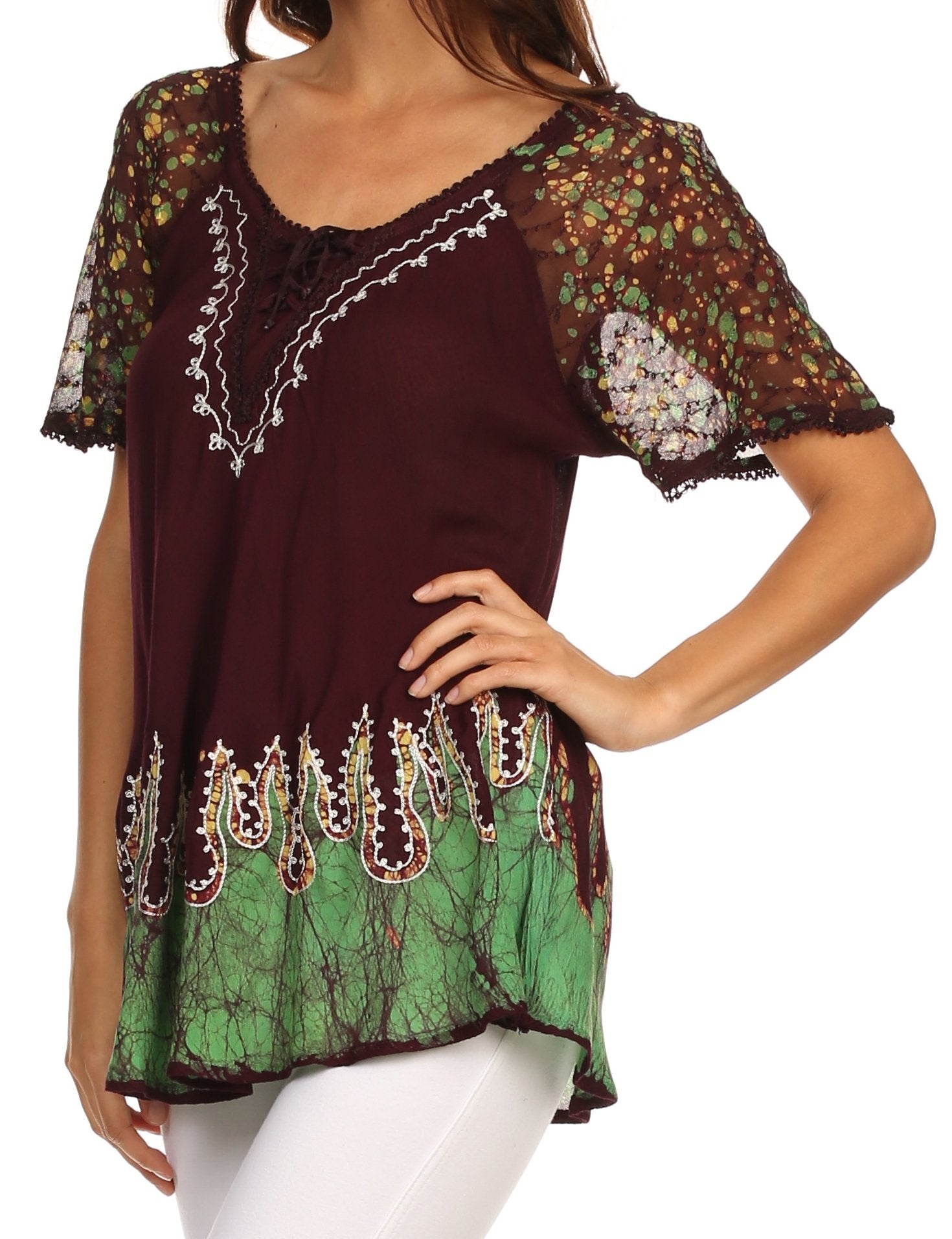 Woman wearing a colorful blouse with floral sleeves and green base.