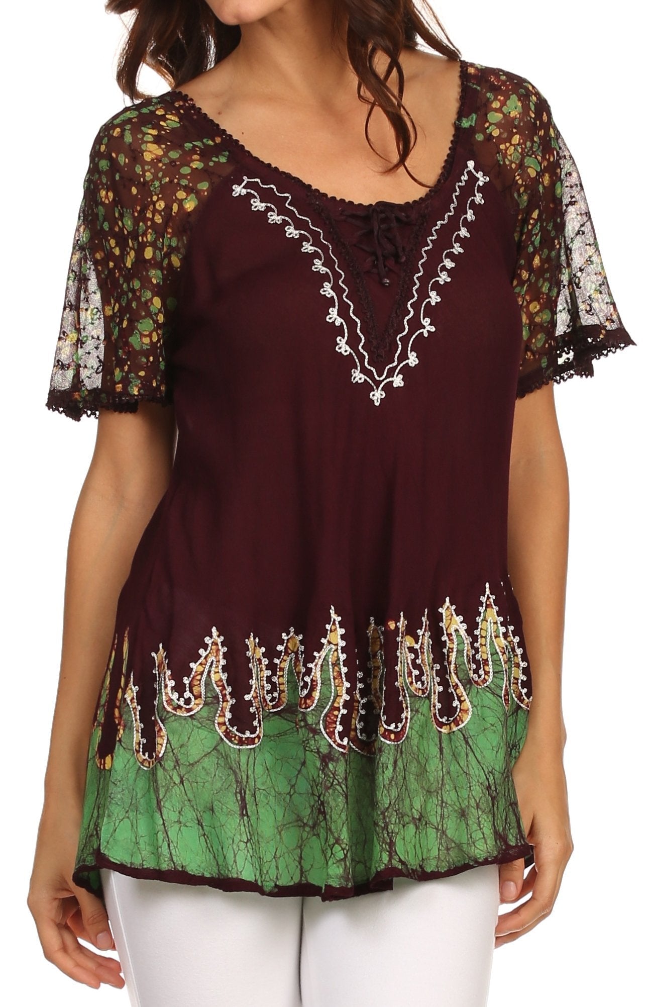 Woman wearing a colorful embroidered top with floral sleeves on a white background