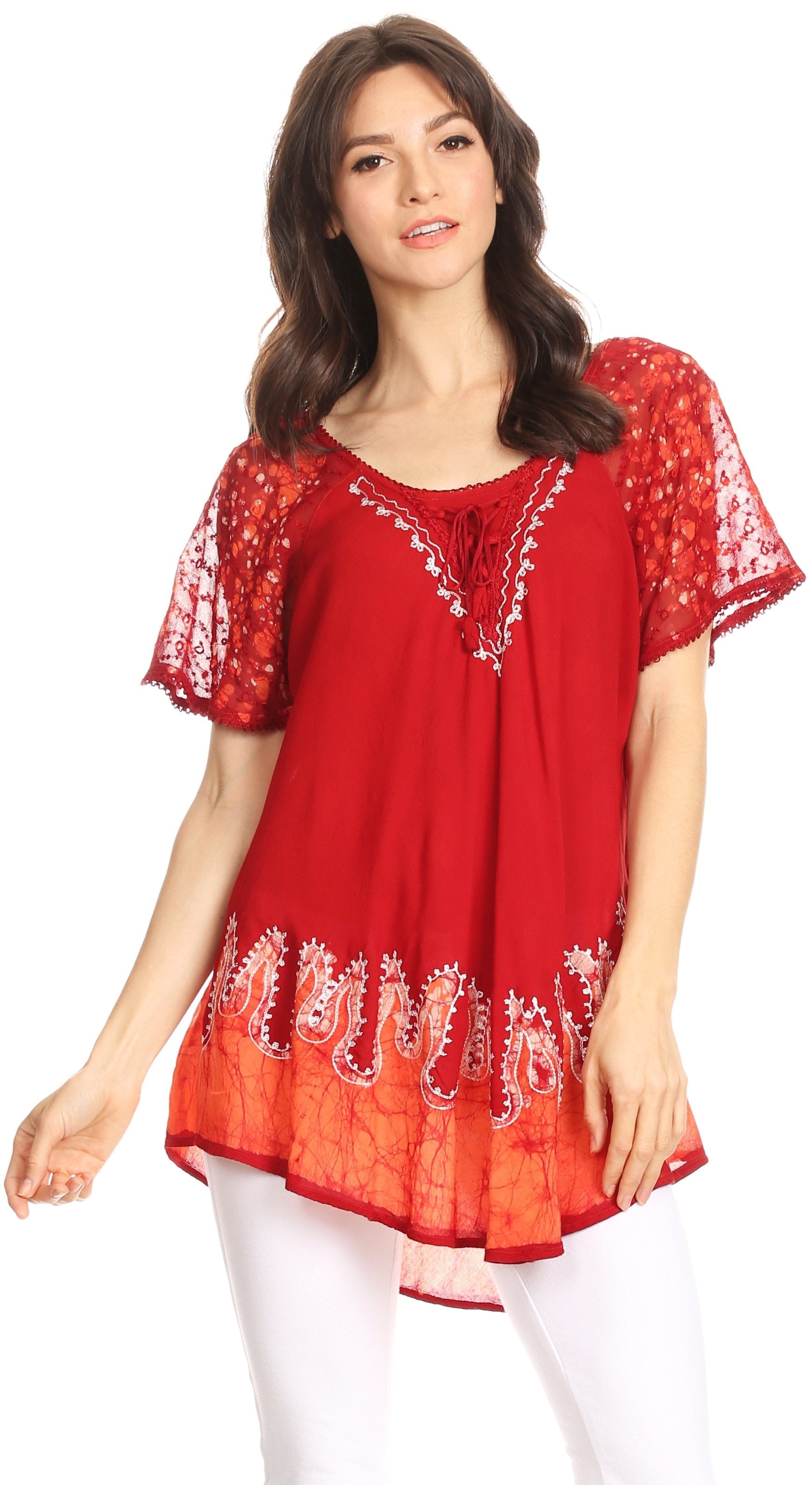 Woman wearing a red embroidered top with white pants on a white background