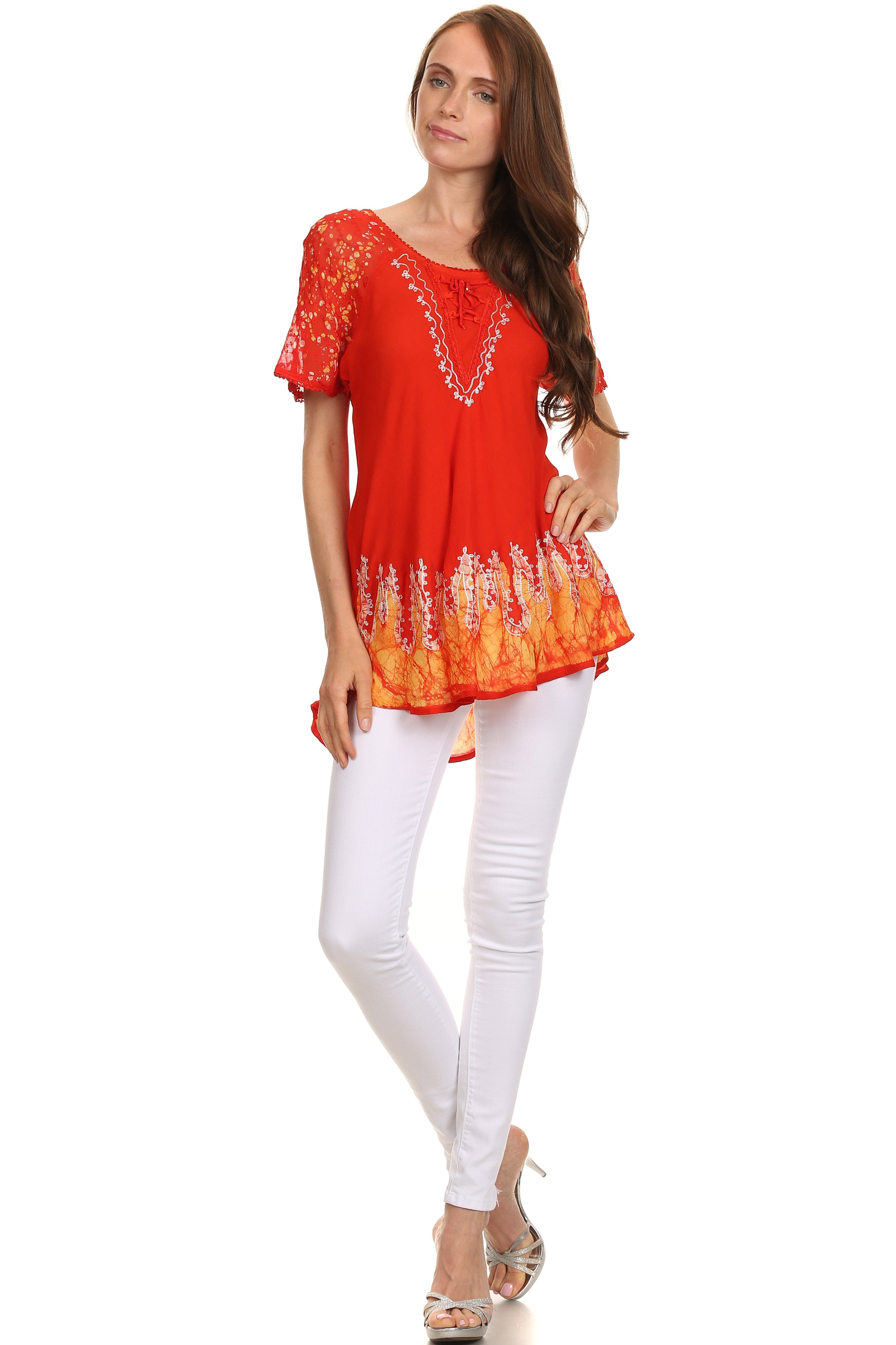 Woman wearing a red lace top and white pants on a white background