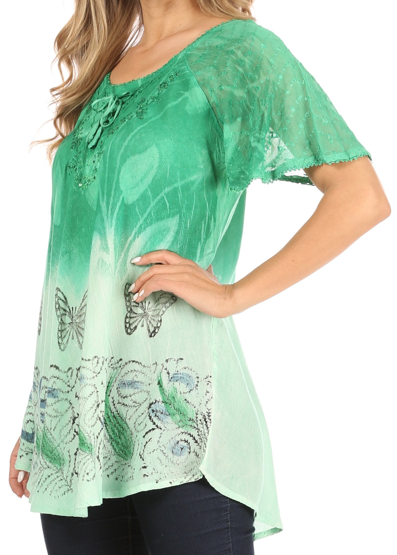 Green blouse with butterfly design worn by a person on a white background