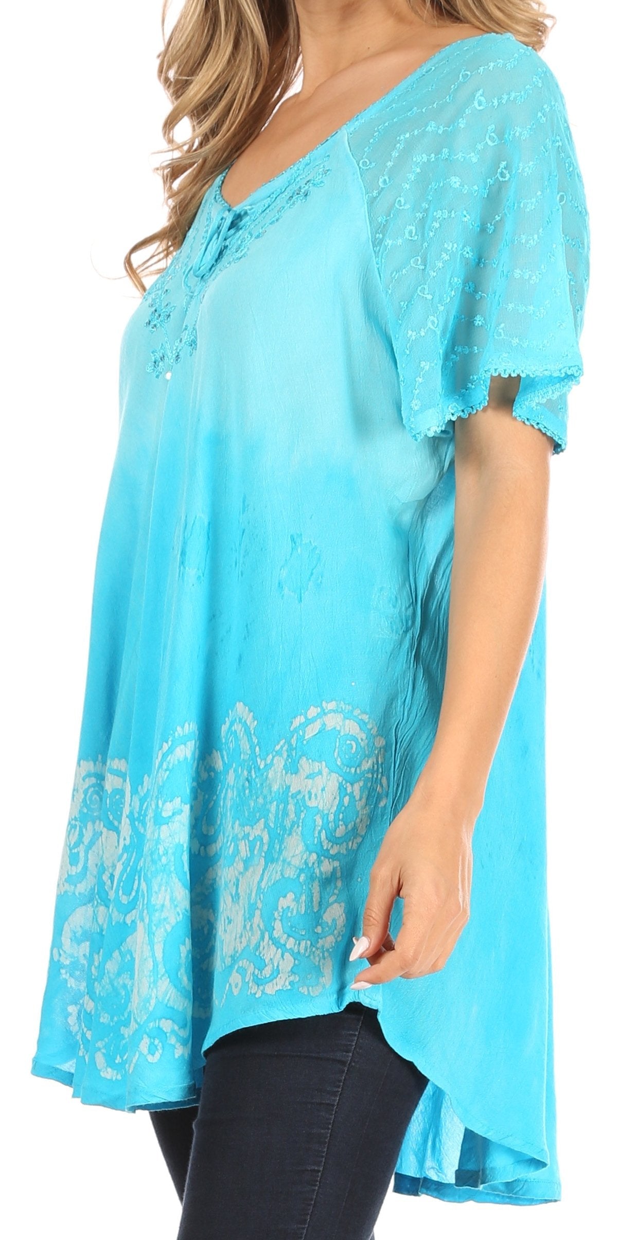 Woman wearing a turquoise lace top with a plain background