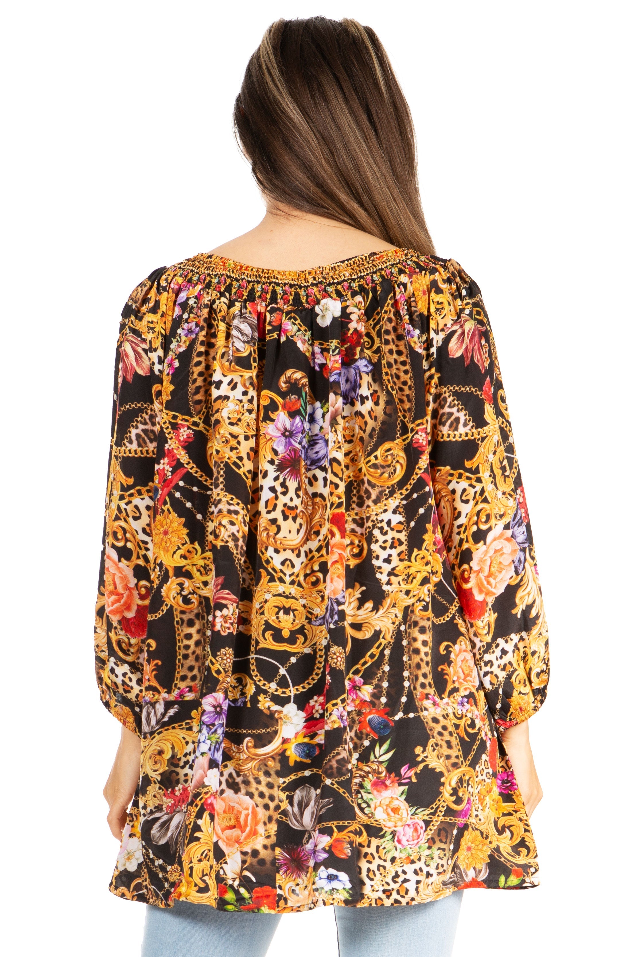 Woman wearing a colorful patterned blouse with long sleeves on a white background