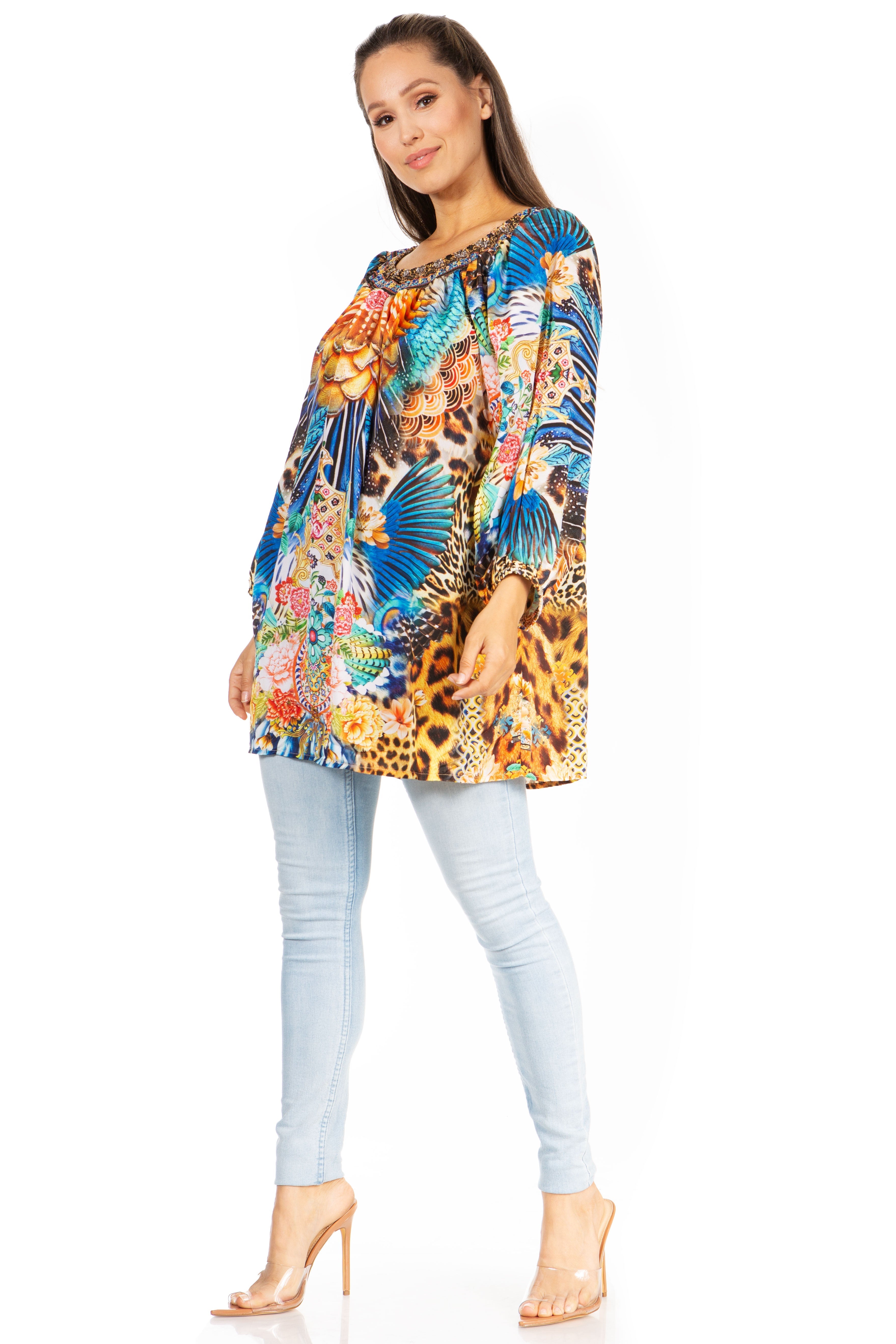 Woman wearing a colorful patterned top and light blue jeans on a white background