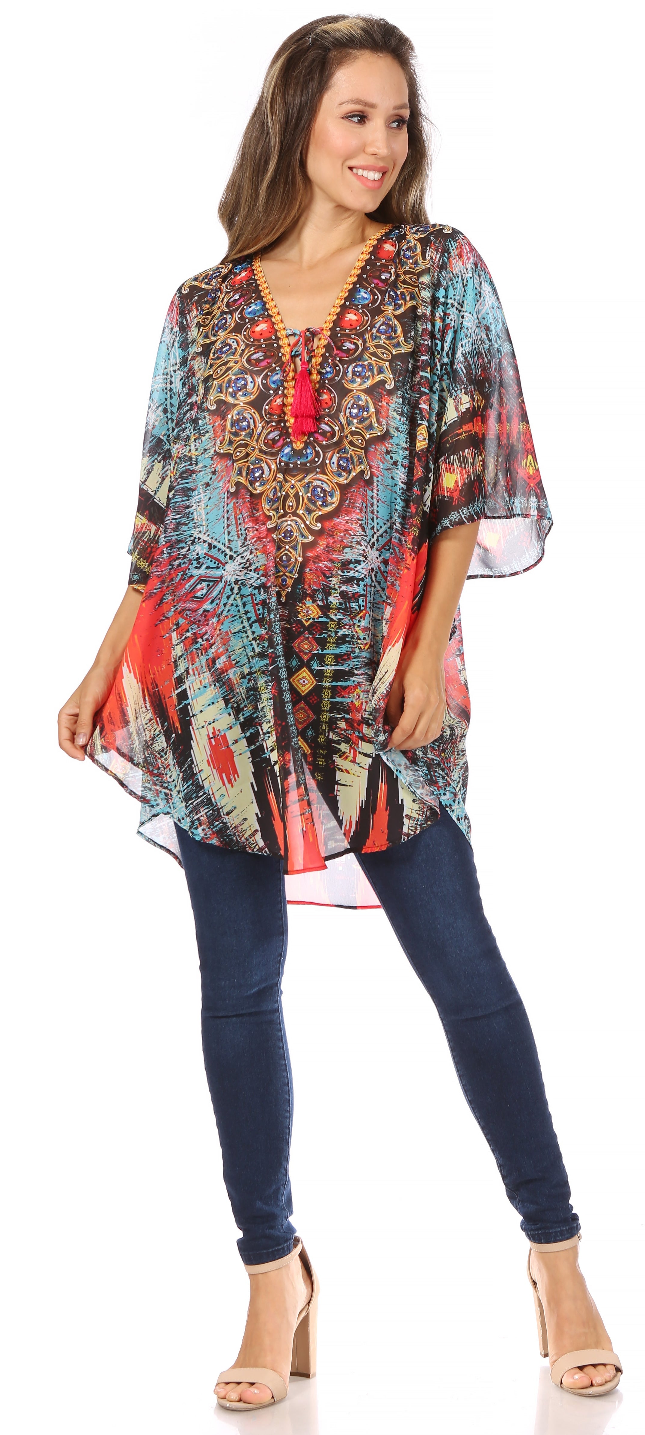 Woman wearing a colorful patterned top and blue jeans on a white background