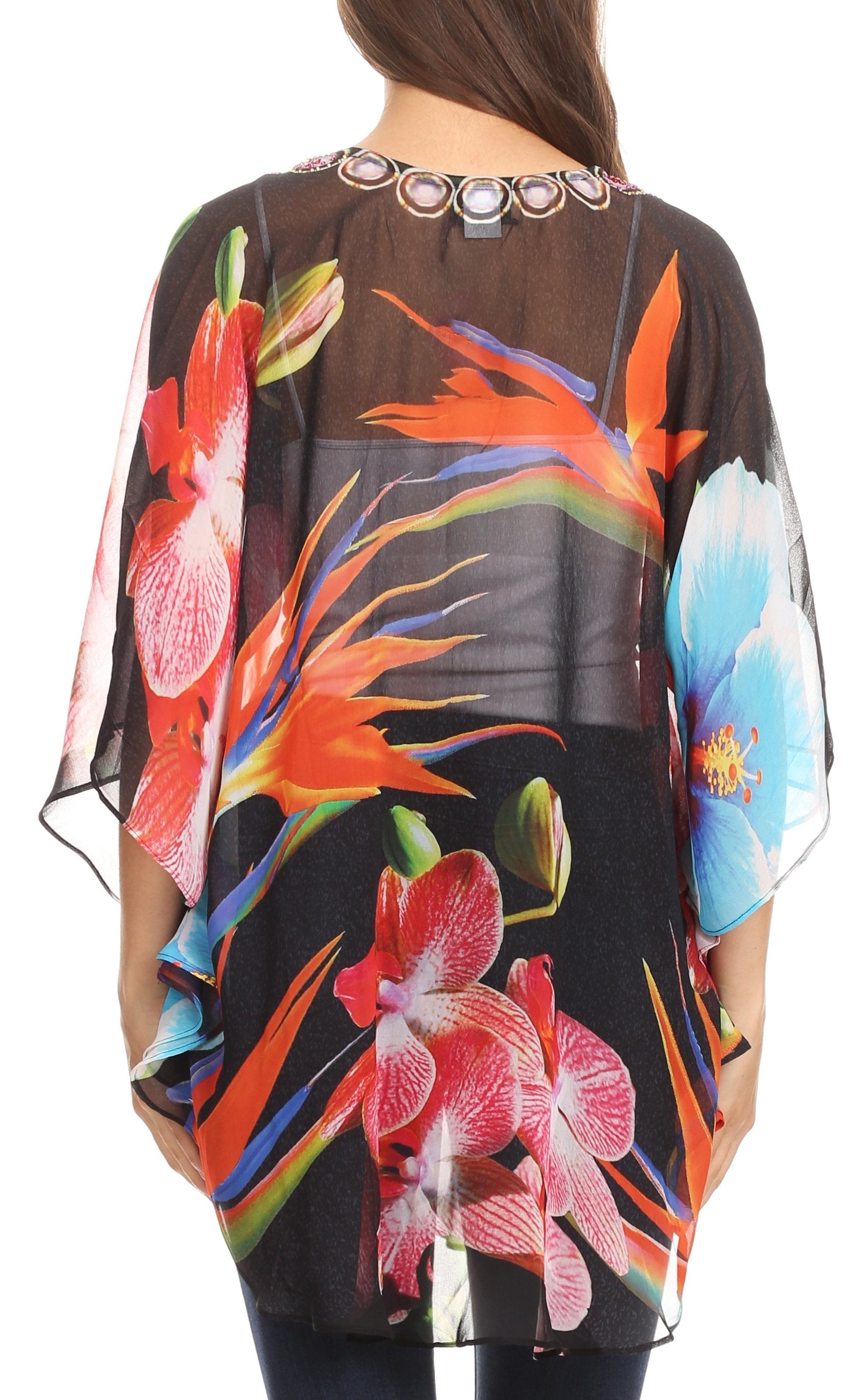Woman wearing a colorful floral sheer top with a black background
