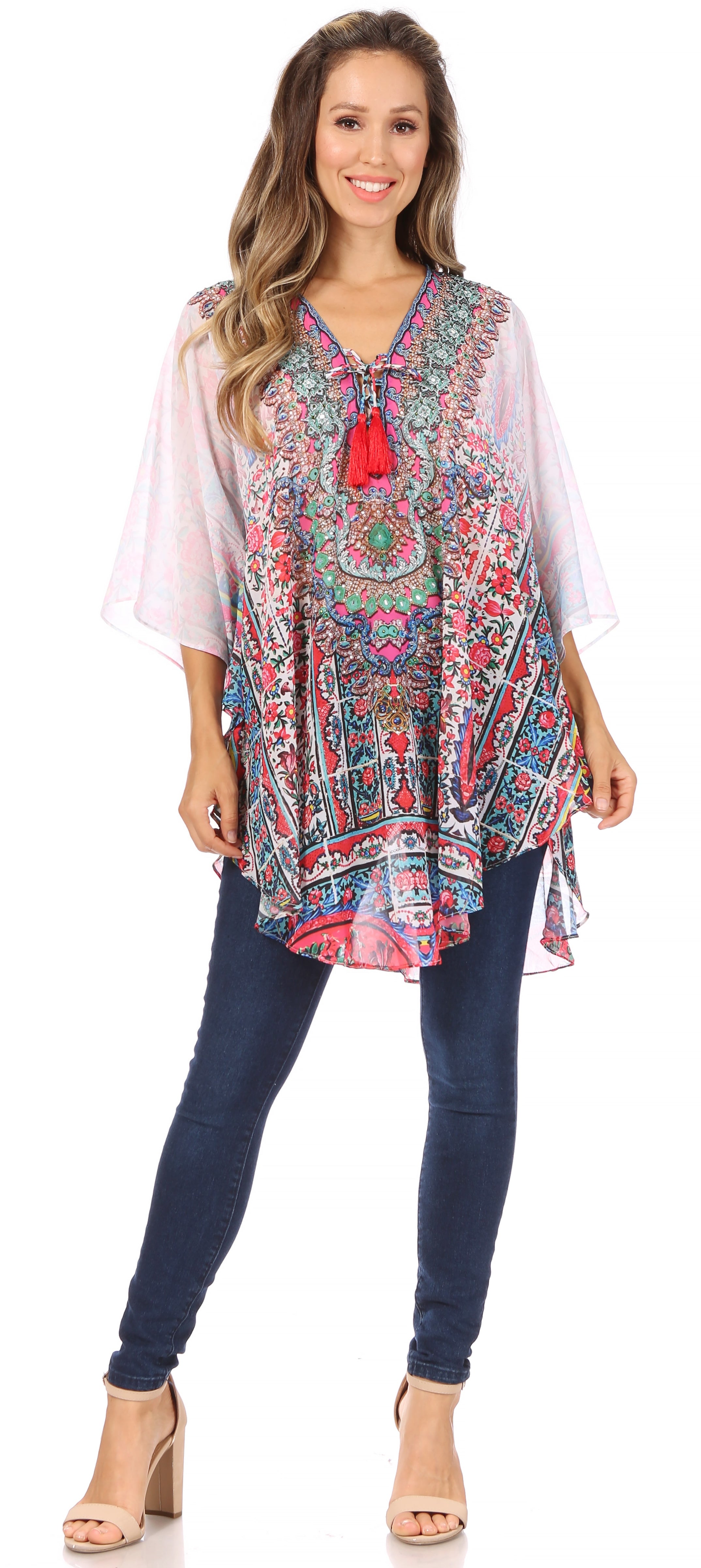 Woman wearing a colorful patterned top with a white overlay and blue jeans on a white background