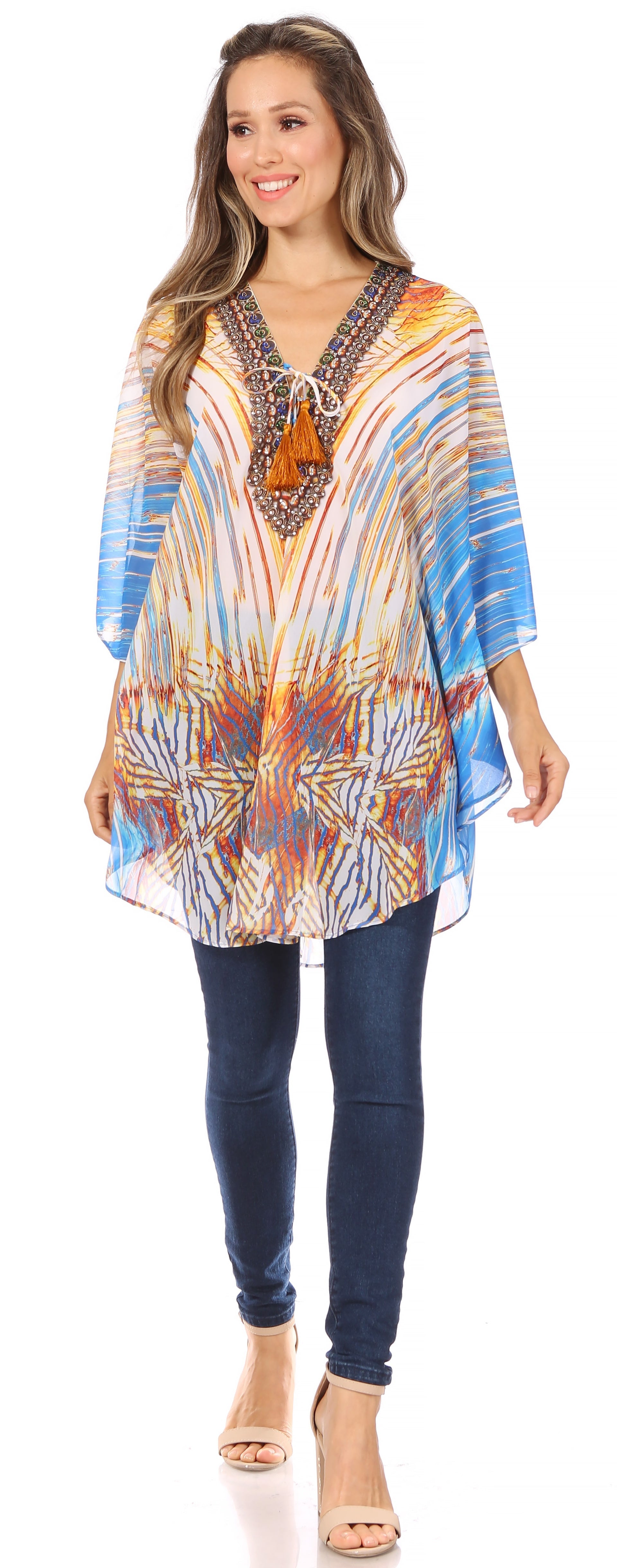 Woman wearing a colorful patterned top and blue jeans on a white background